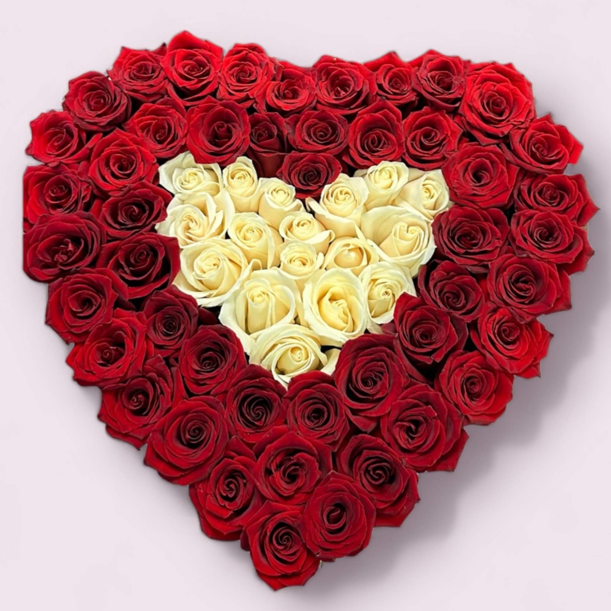 Heart-shaped arrangement of red and white roses