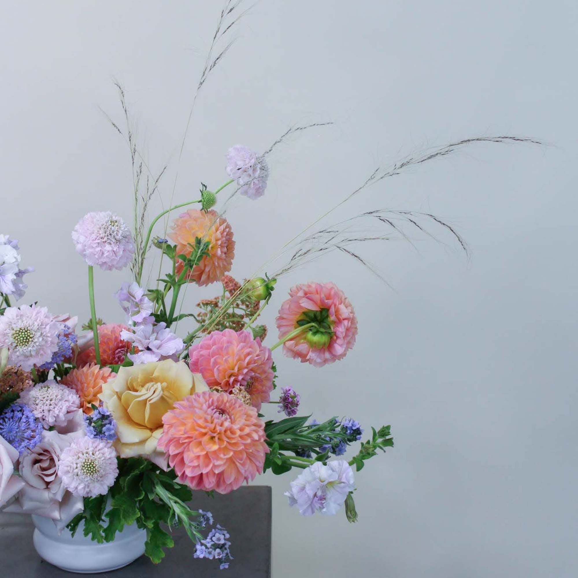 Pastel flower arrangement in a white vase with tall airy stems