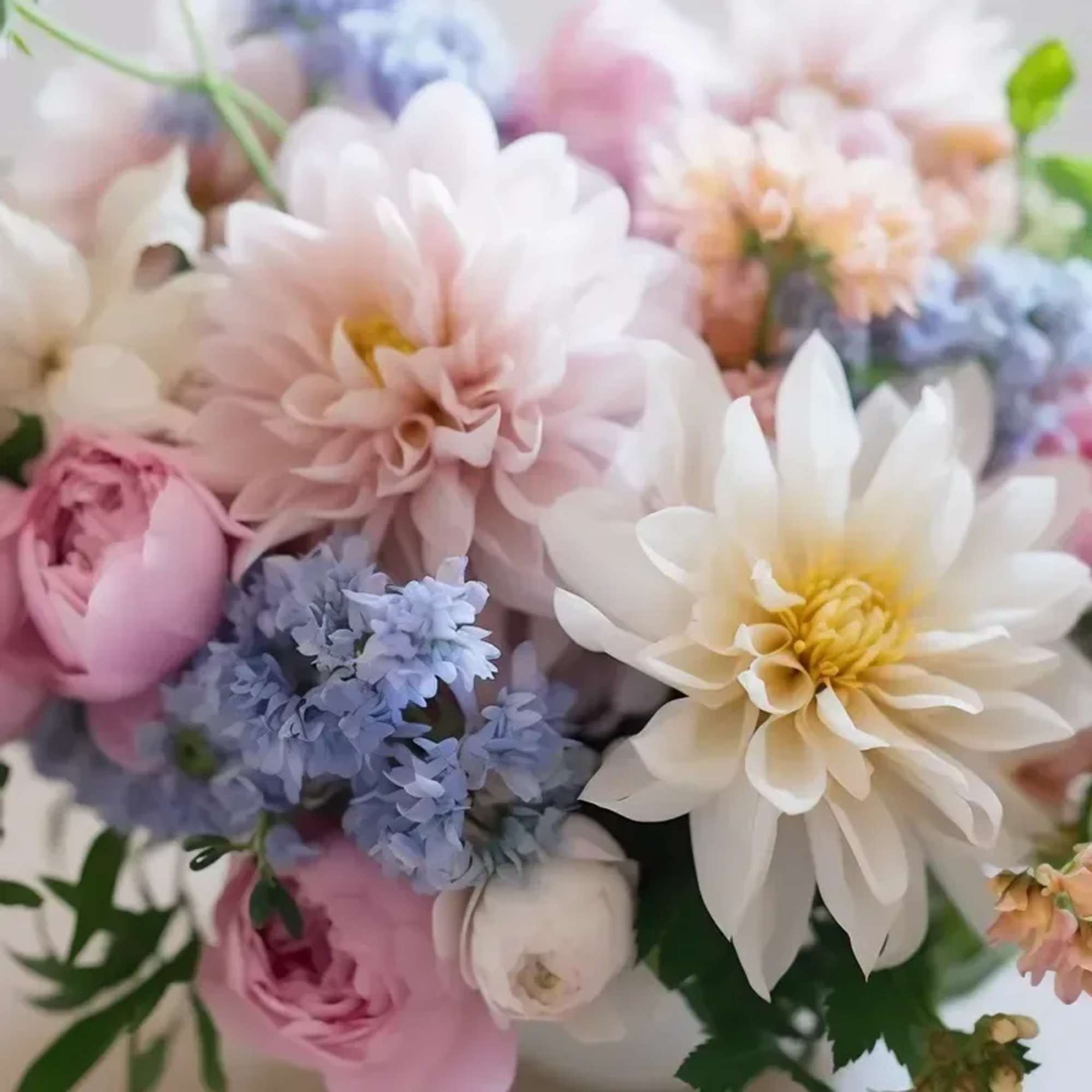 An arrangement of seasonal blooms in a Pastel color scheme, no vase.