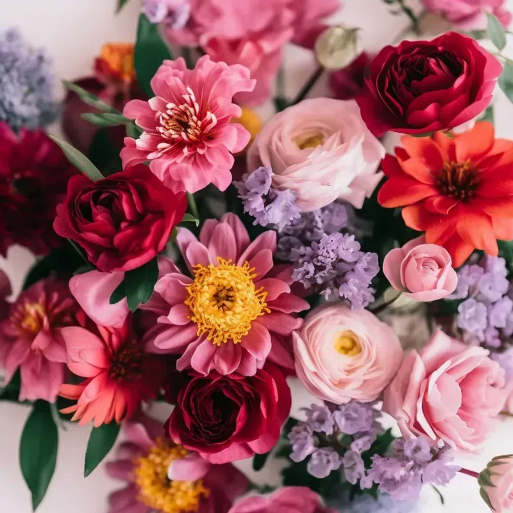 An arrangement of seasonal blooms in Berry &amp; Bright, shades of coral