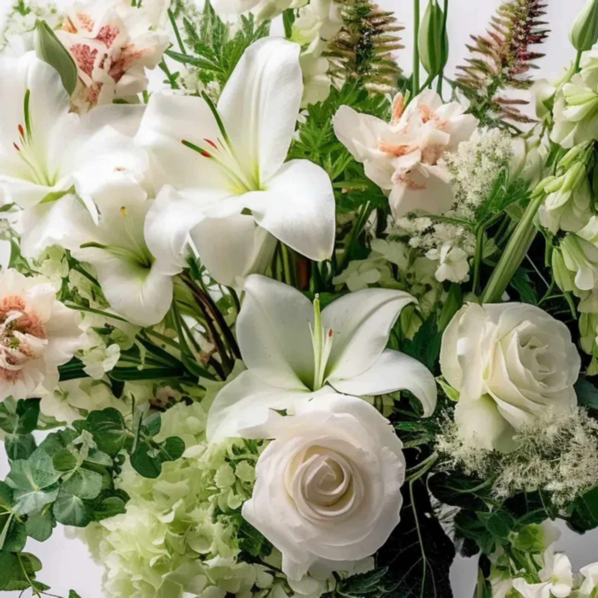 An arrangement of seasonal blooms for Sympthy arranged no Vase, . PLEASE