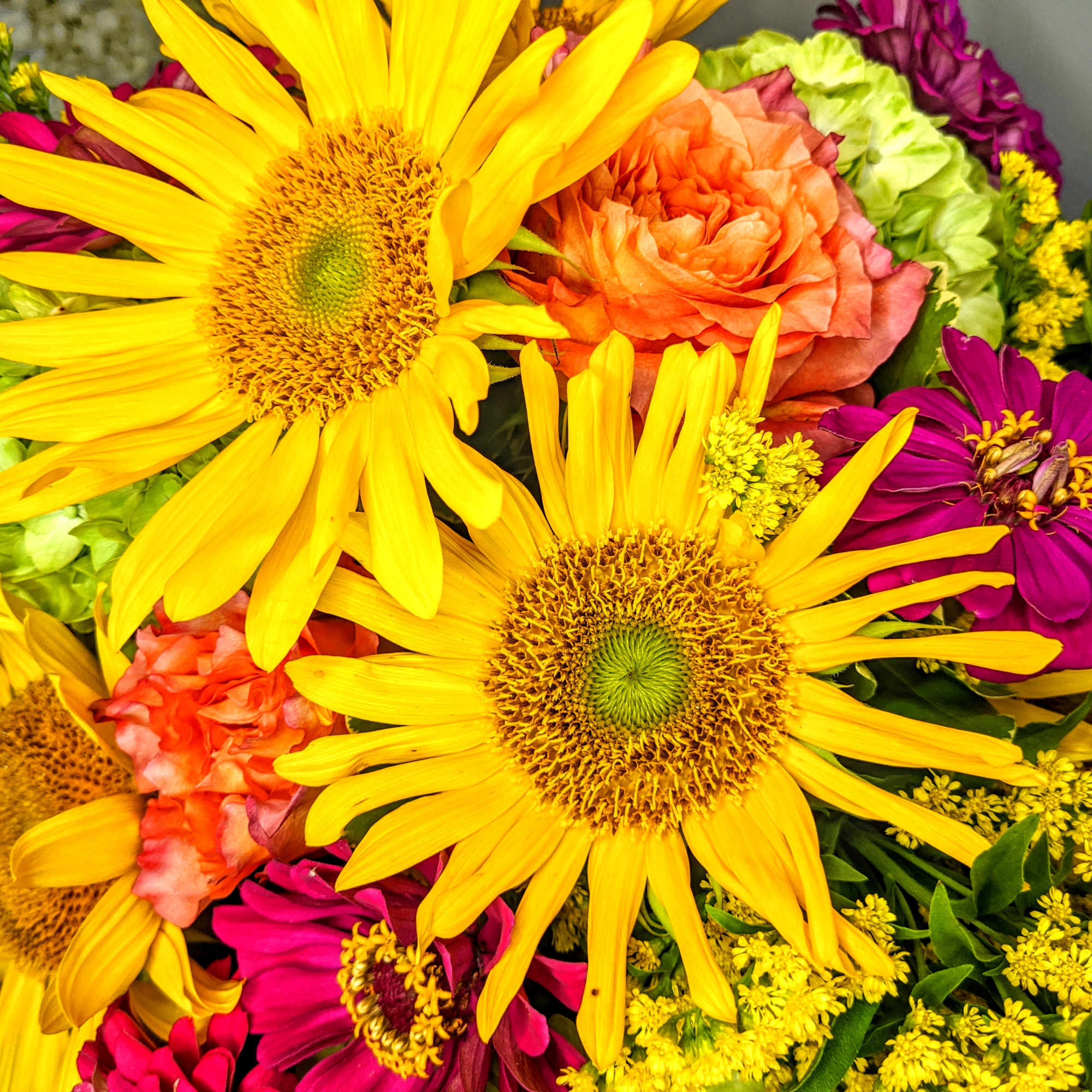 Bright bouquet with yellow sunflowers, orange roses, and magenta flowers
