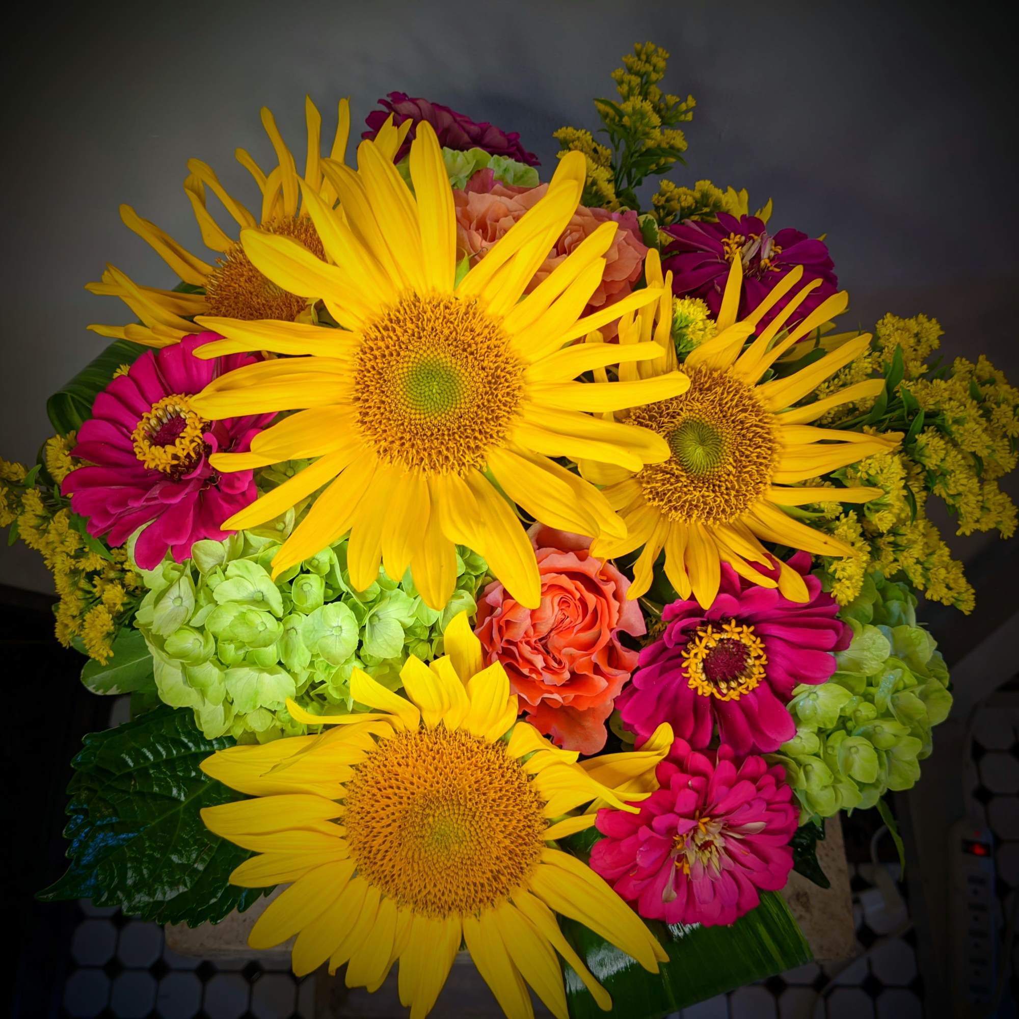 Bright bouquet with yellow sunflowers, pink flowers, and green hydrangeas