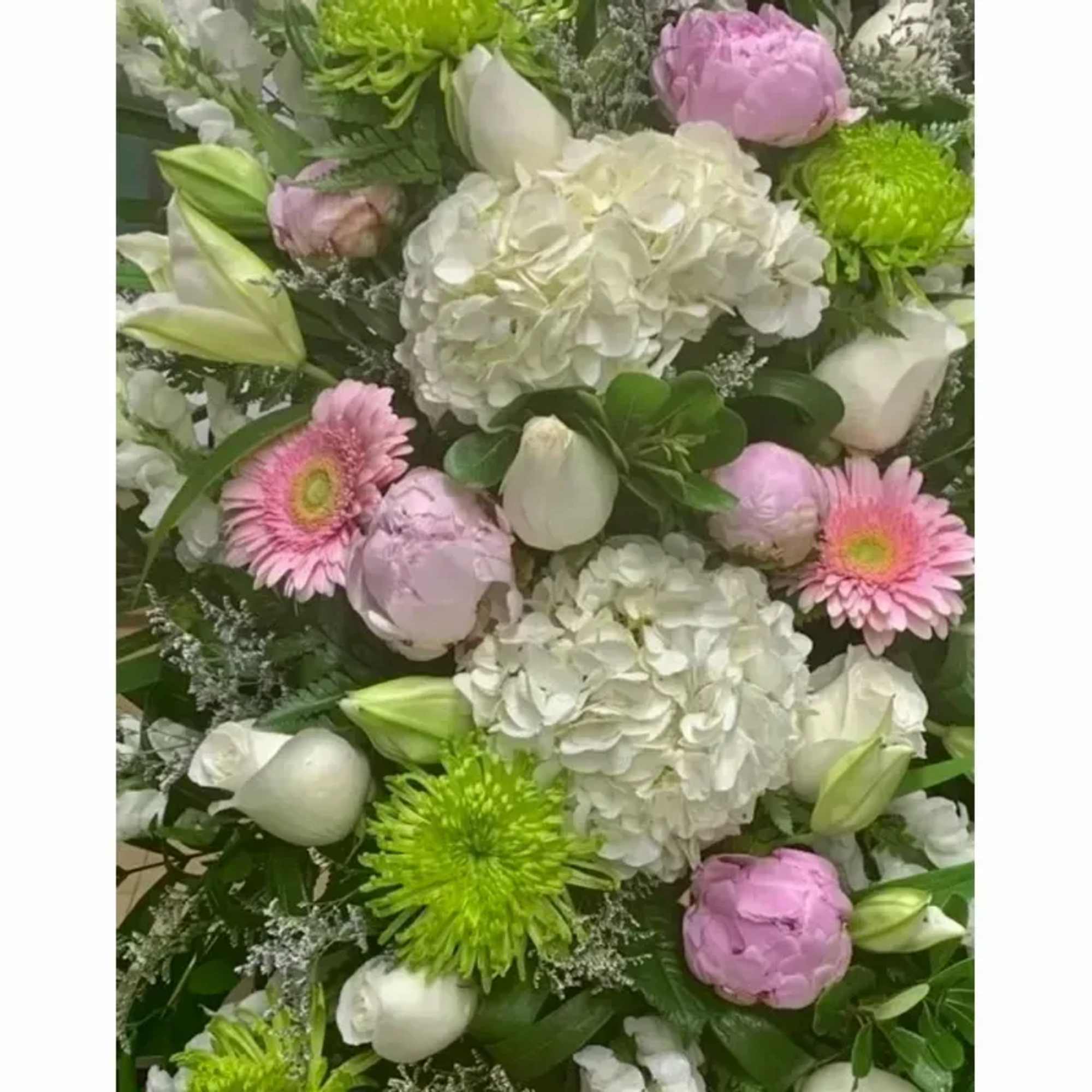 The Designer will put together a spray of mixed flowers reflecting the