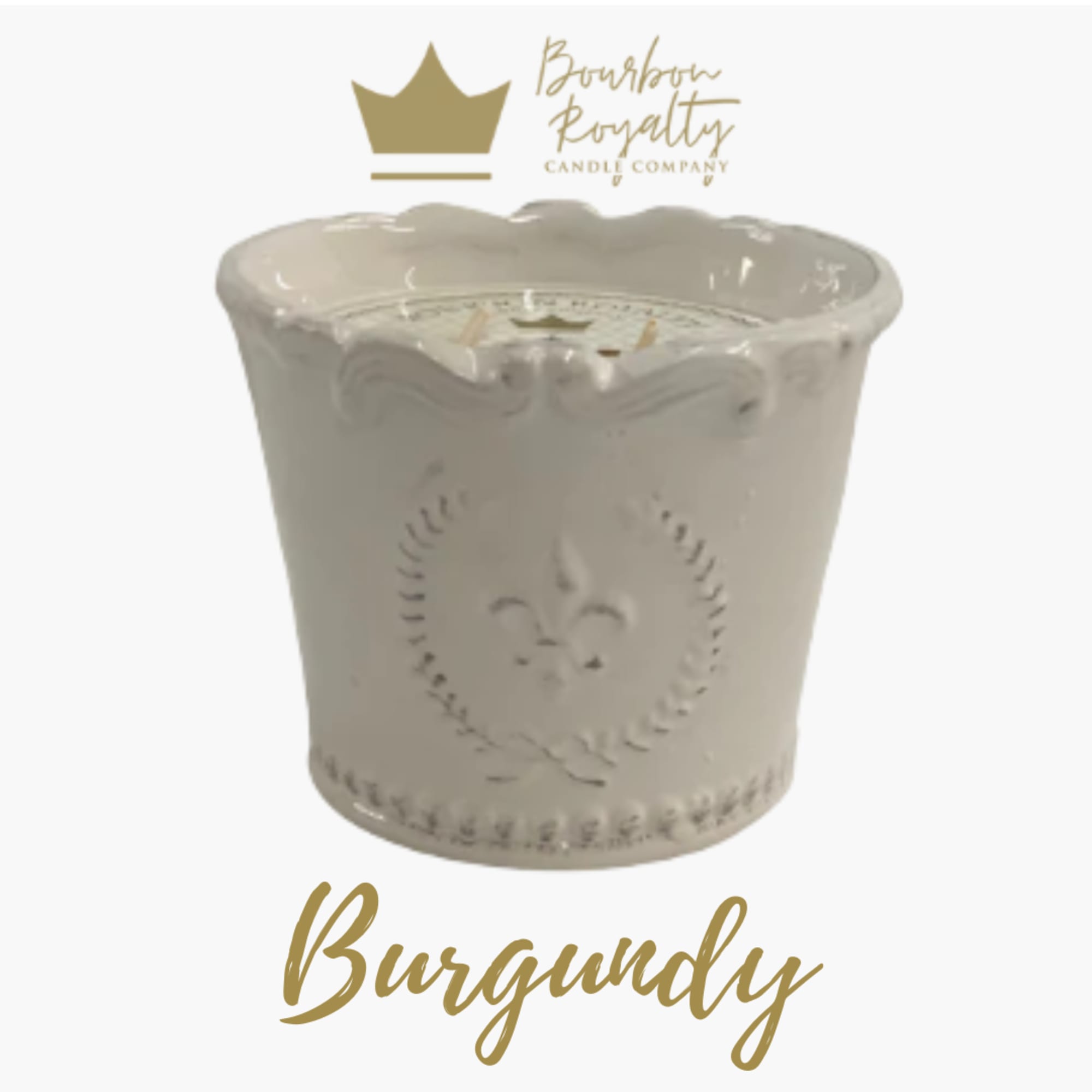 White decorative candle in a ceramic container with gold branding