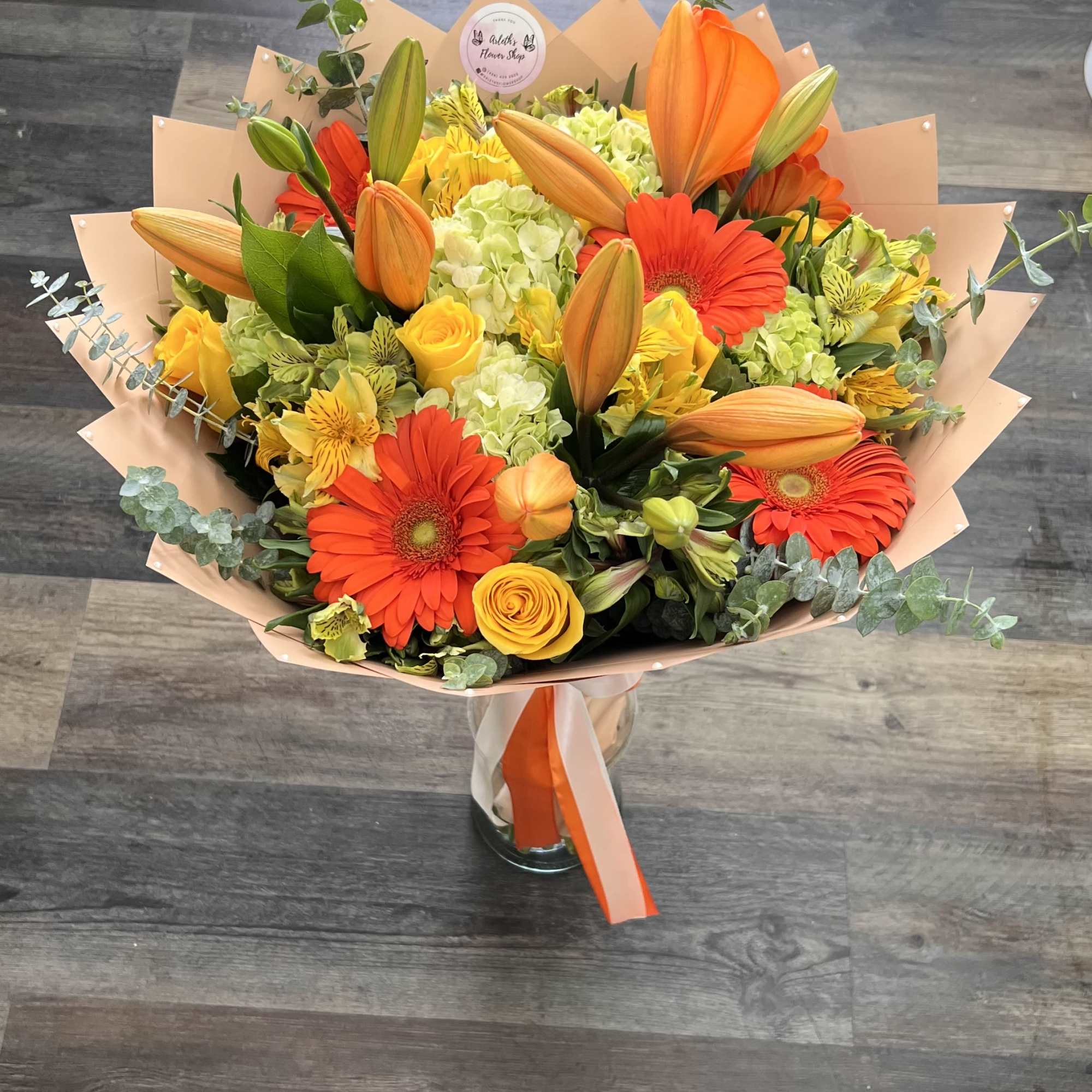 &ldquo;A bright and cheerful bouquet featuring vibrant orange lilies, gerbera daisies, yellow