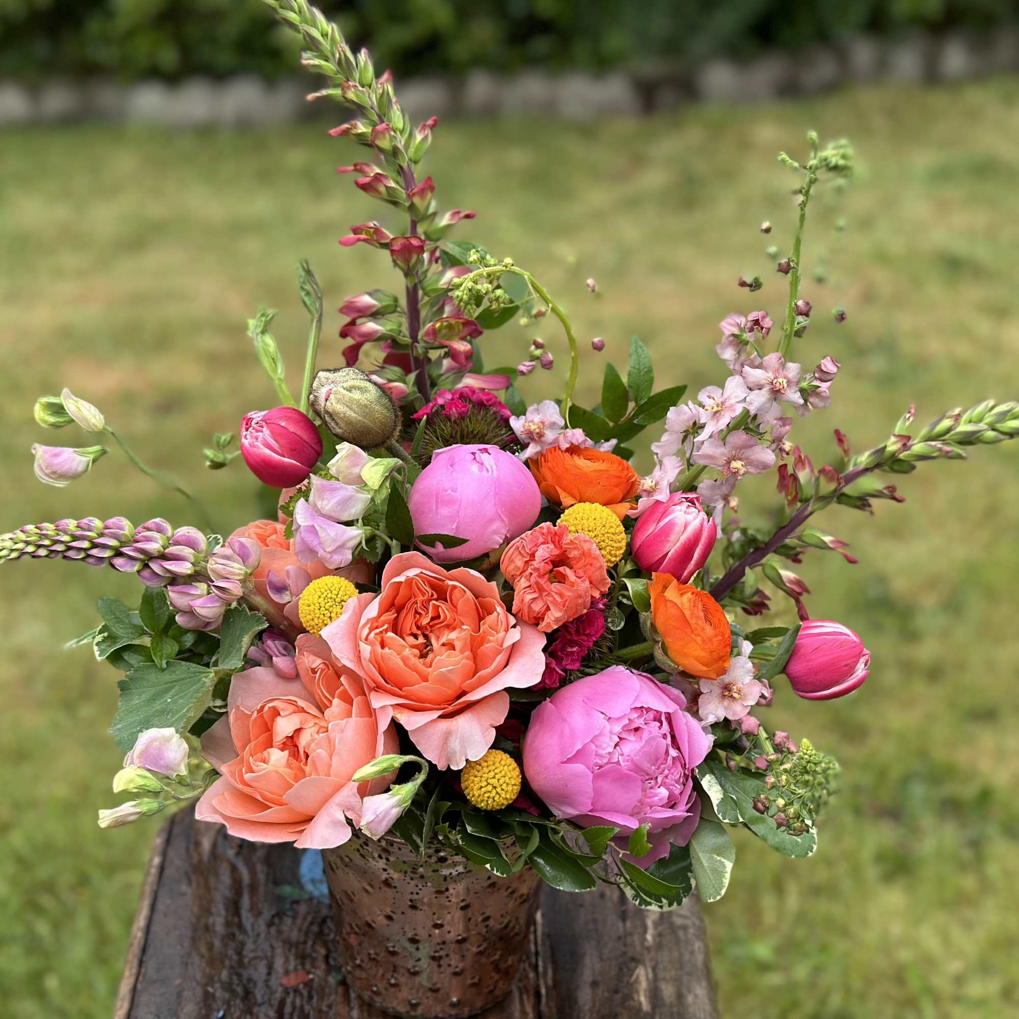 Colorful bouquet in a copper vase with pink, coral, orange, and yellow blooms