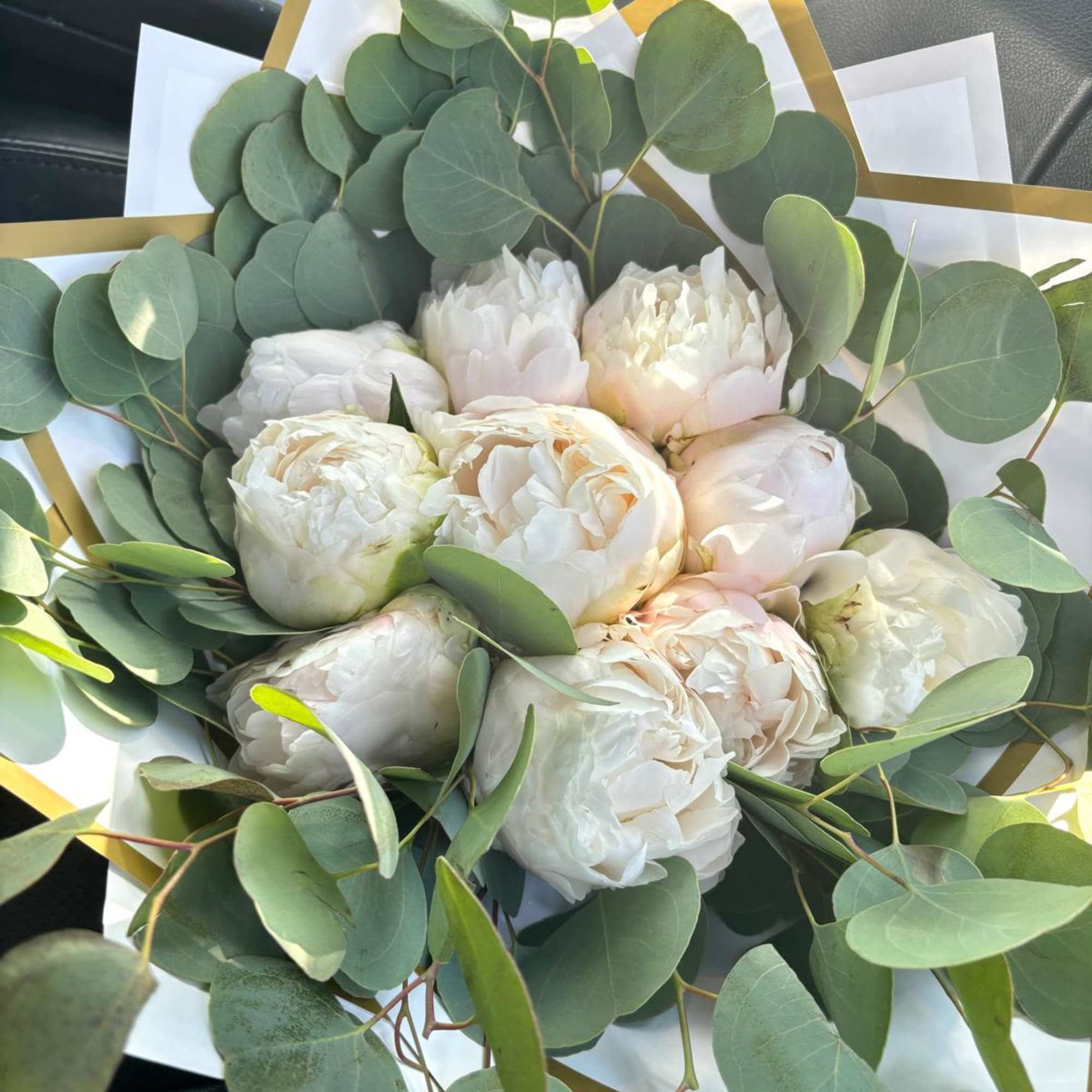 White peony bouquet with round eucalyptus leaves and white paper wrap