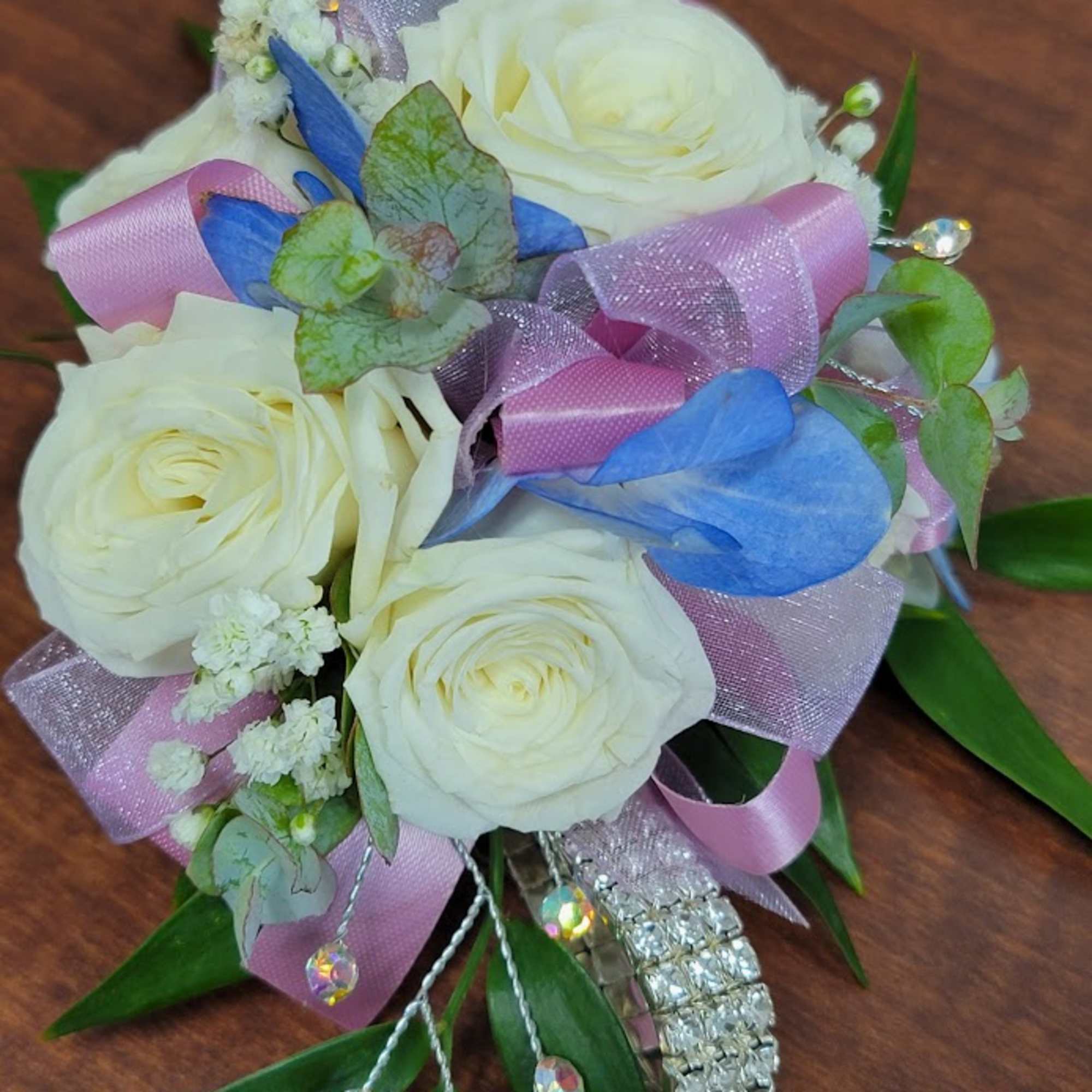White rose bouquet with pink and blue ribbons and crystal accents