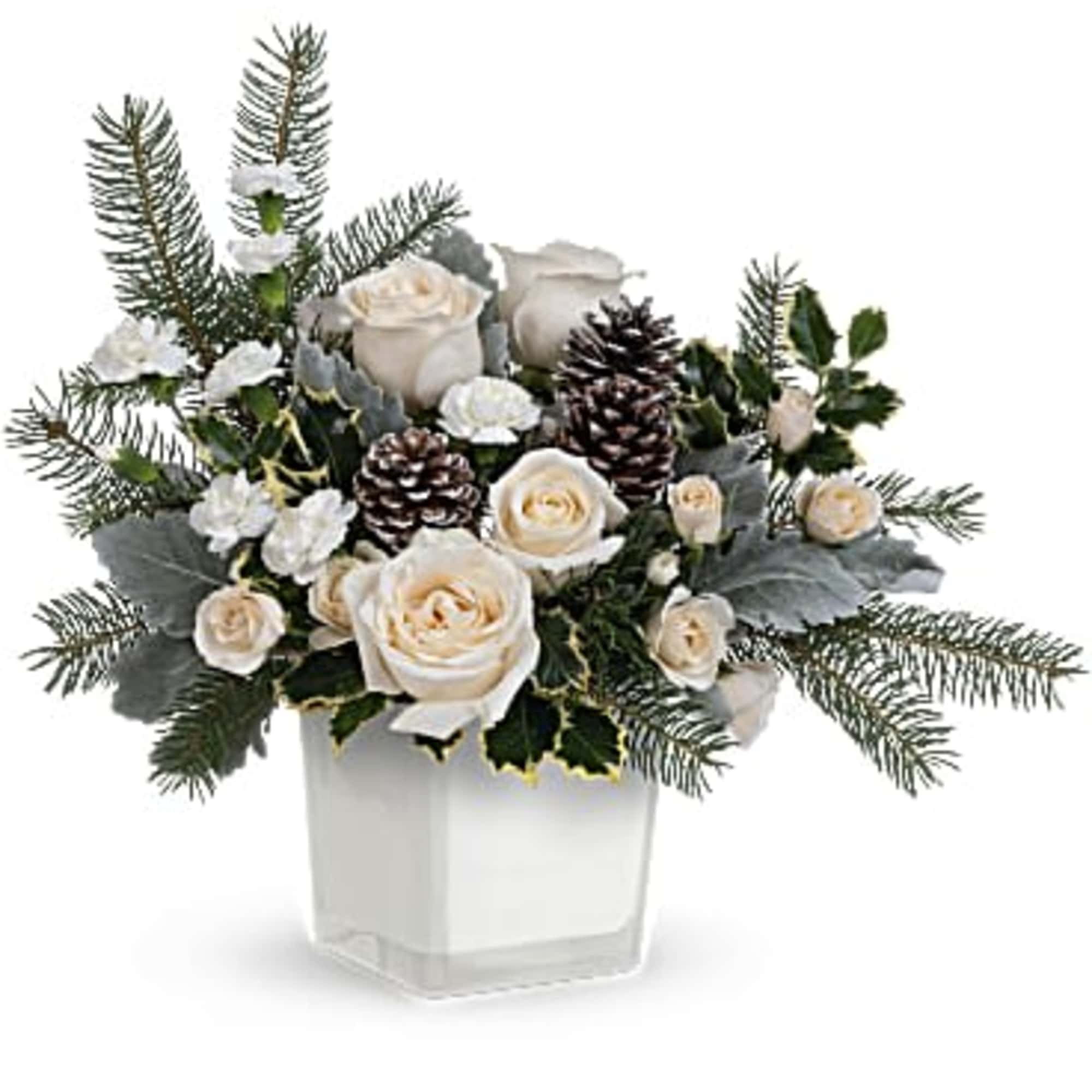 White roses and pinecones arranged in a clear square vase