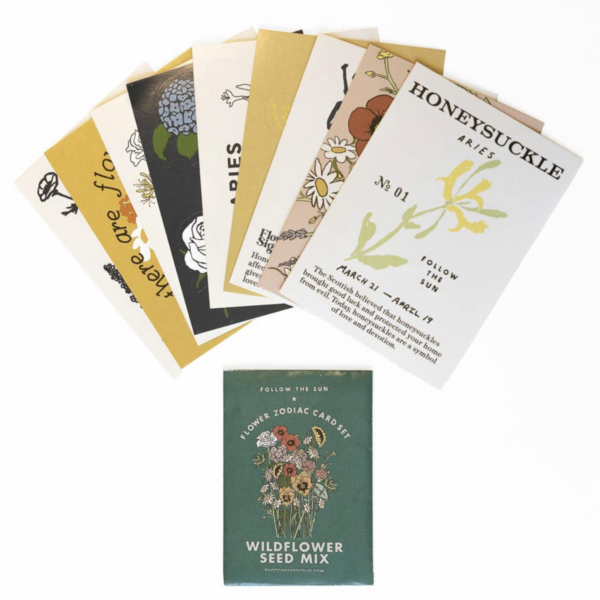 Assorted flower seed packets fanned out above a wildflower seed mix box