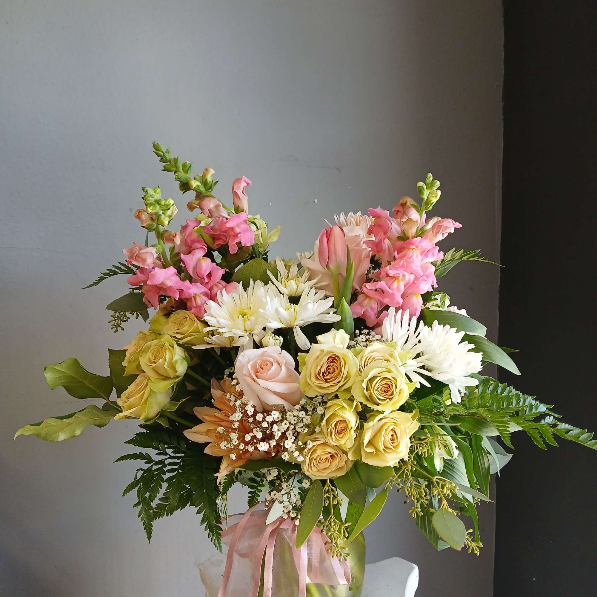 This beautiful flower arrangement of fresh mixed seasonal blooms is made by