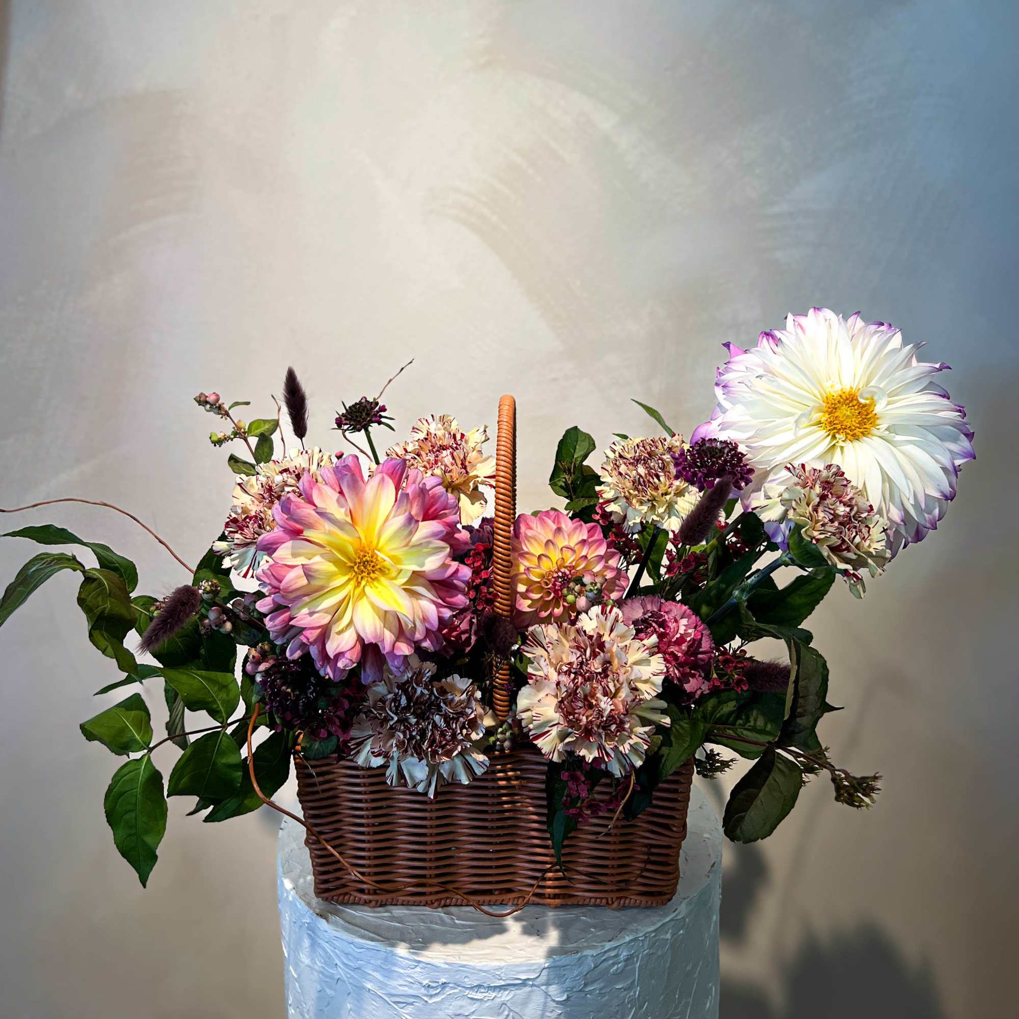 Basket arrangement with colorful dahlias and carnations