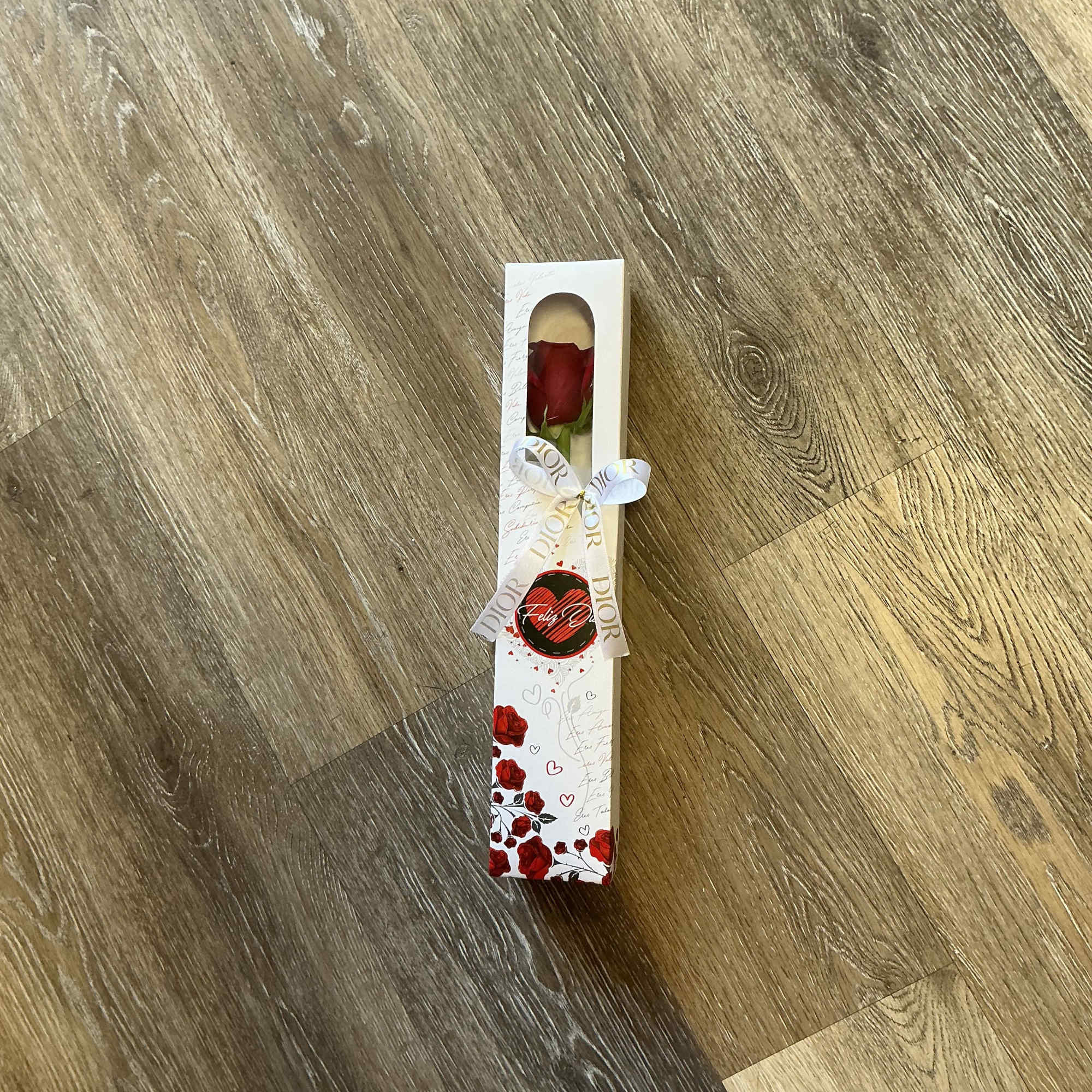 Single red rose in a decorated gift box with a ribbon
