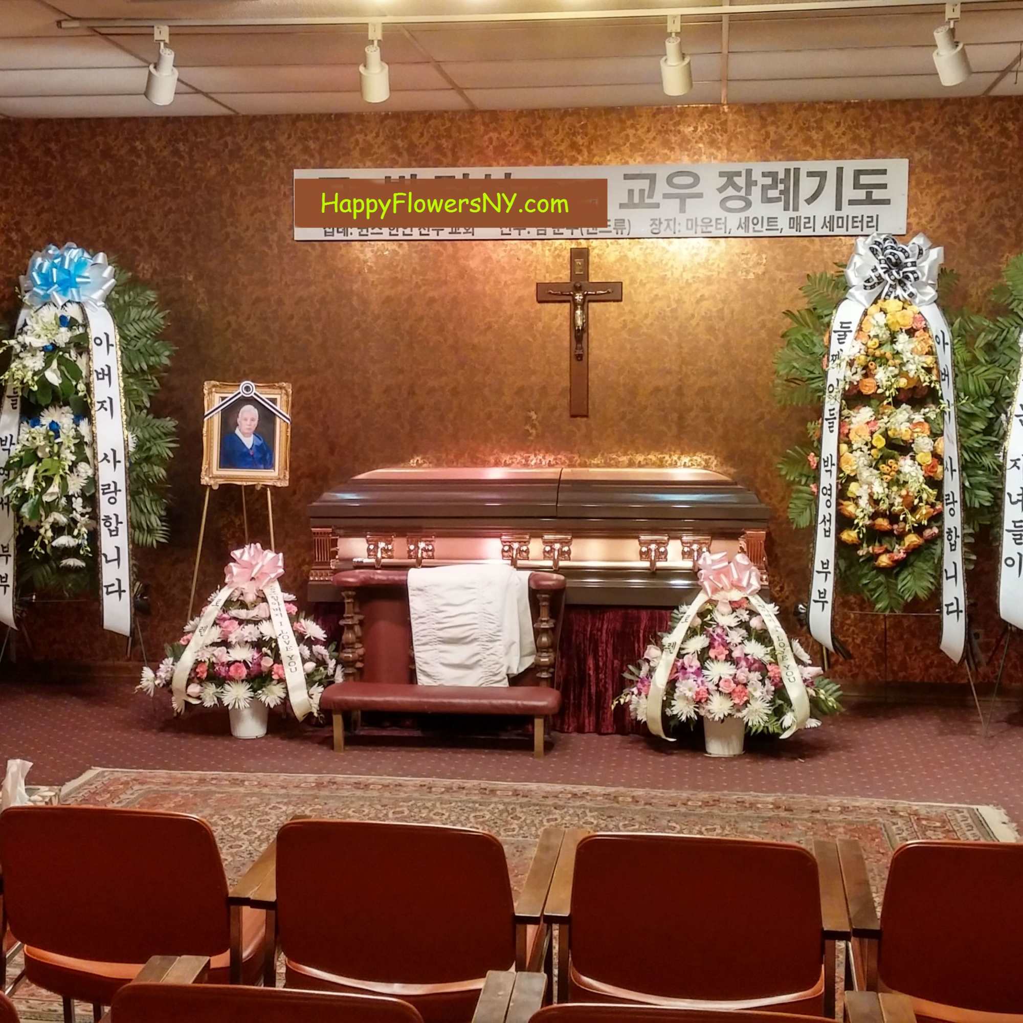 Funeral chapel with floral wreaths around a casket and cross