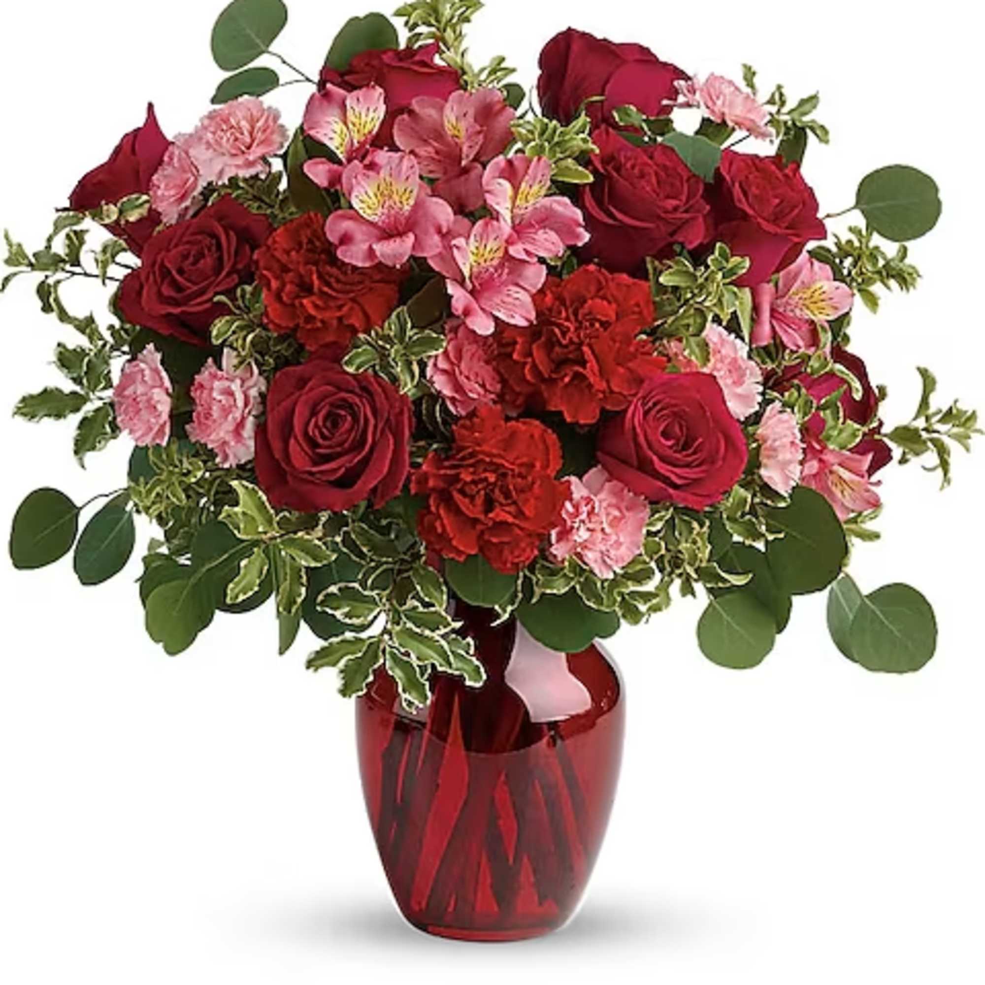 Red roses and pink flowers in a red glass vase
