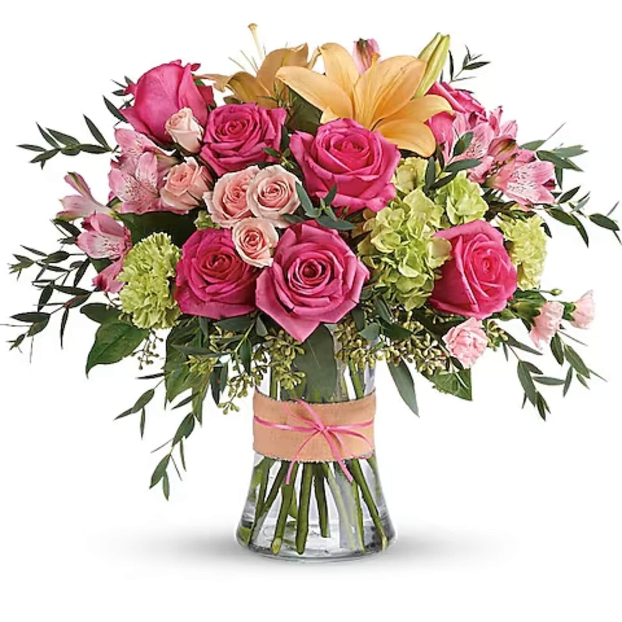 Bouquet of pink roses, lilies, and green hydrangeas in a glass vase