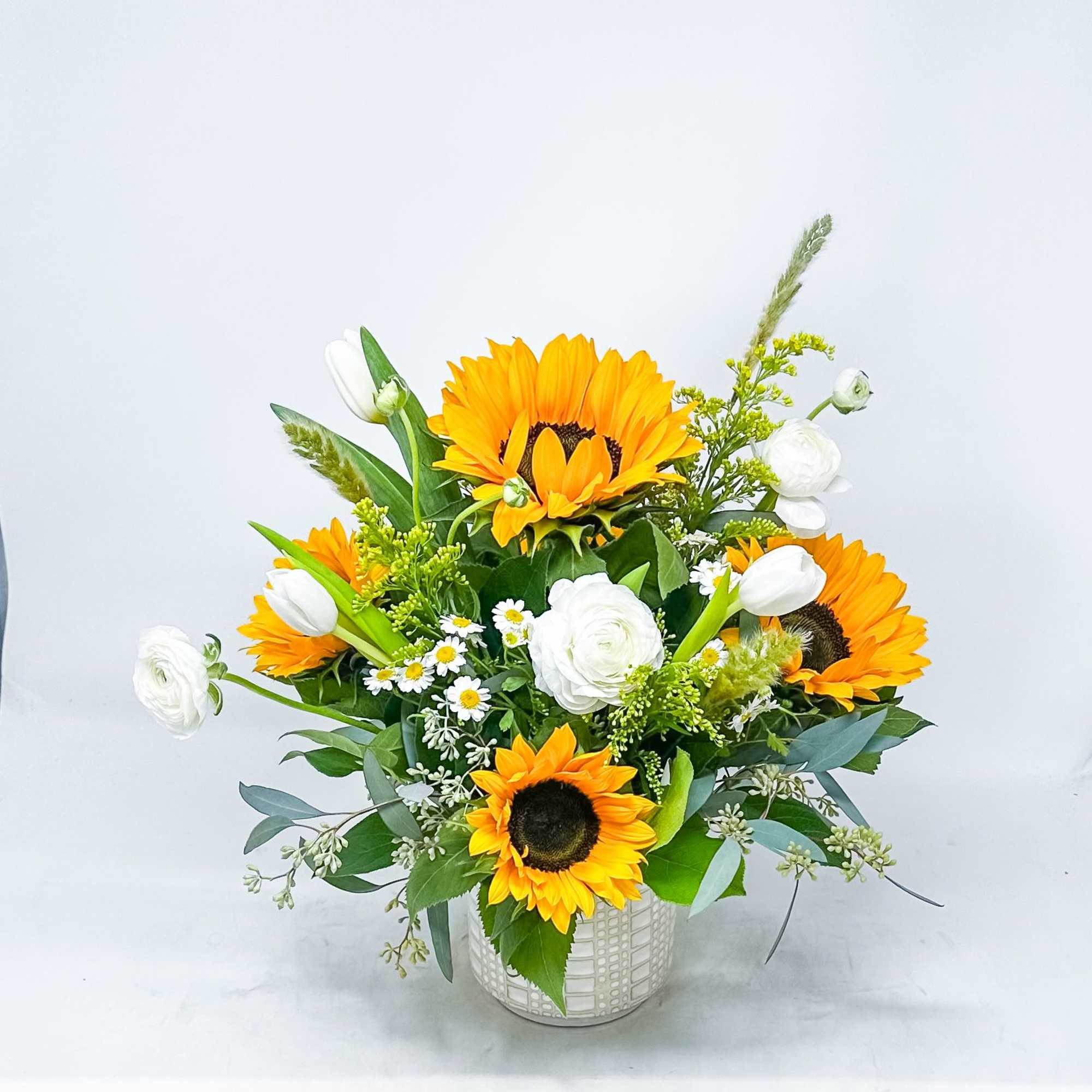 Sunflower and white tulip arrangement in a white vase