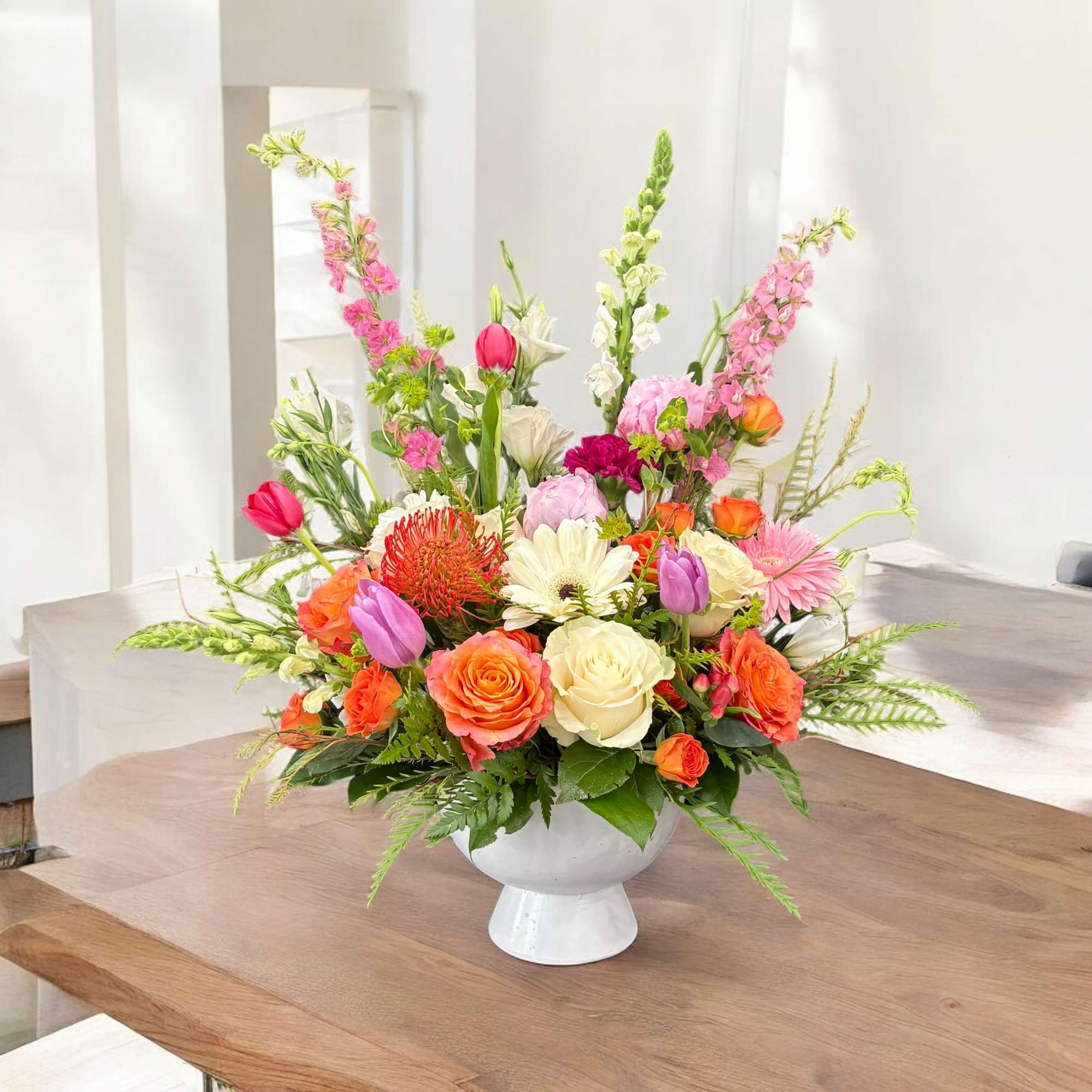 Colorful mixed flower arrangement in a white pedestal vase, photo 2 of 2