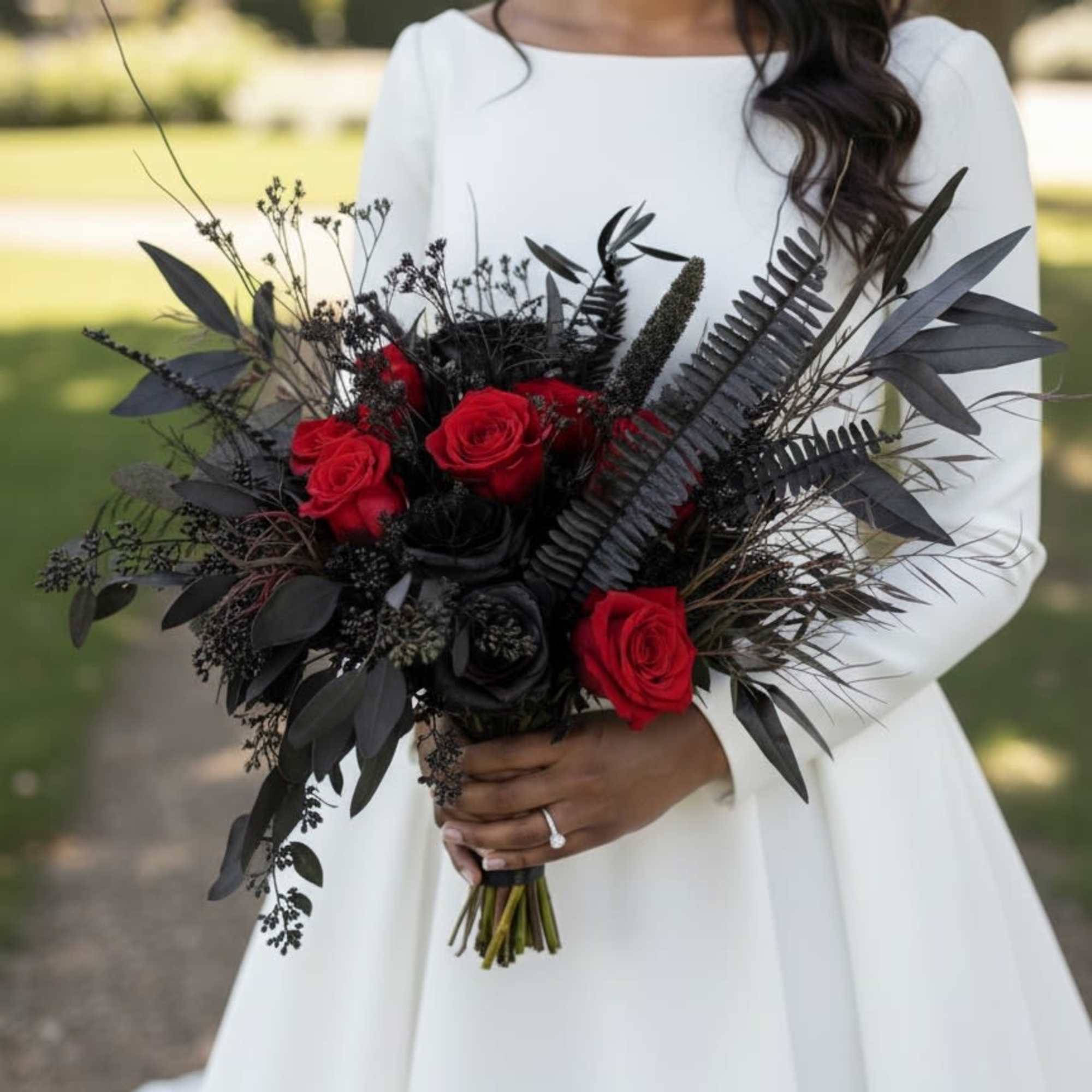 Bride holding a bouquet of red and black roses