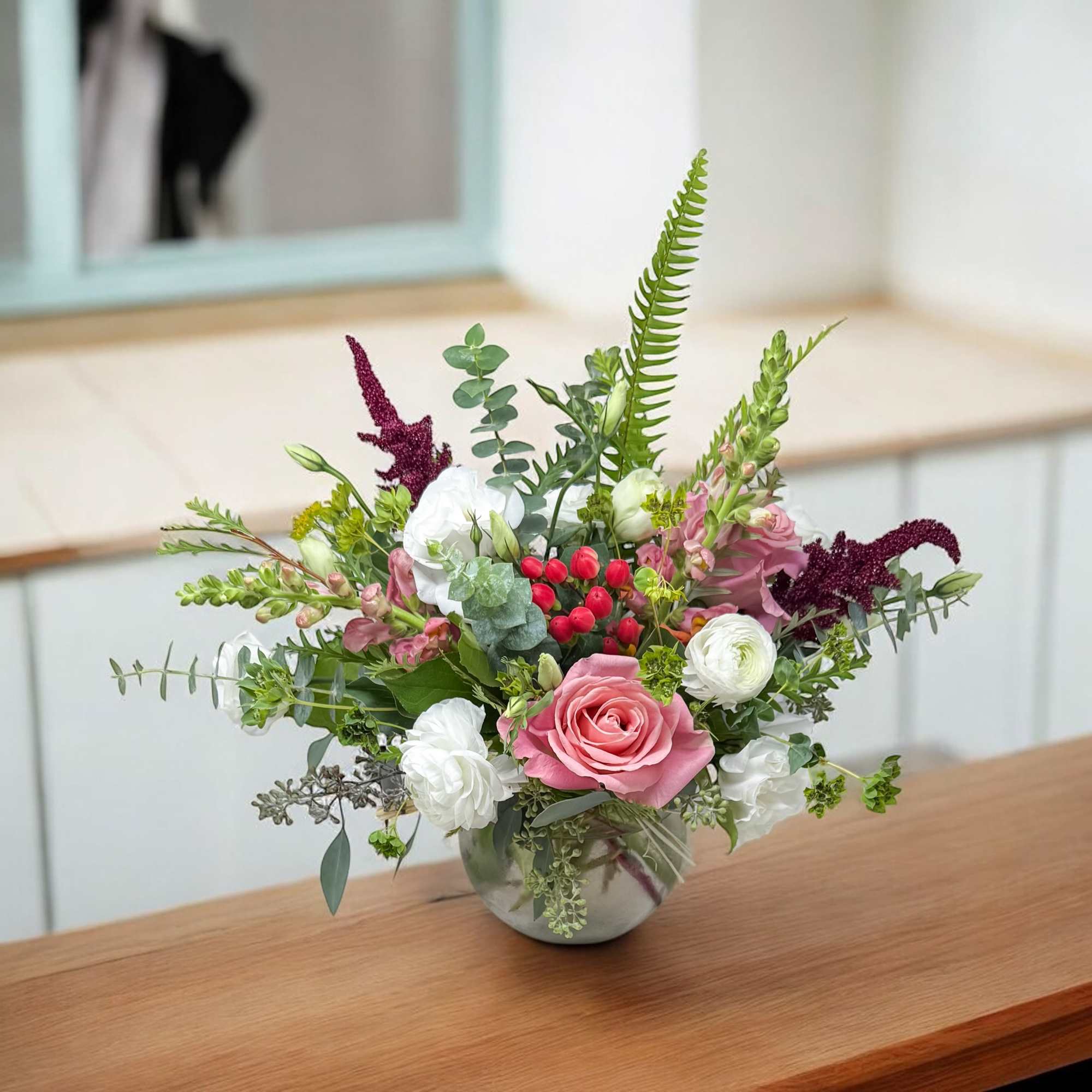 Mixed bouquet in a round glass vase with pink and white flowers