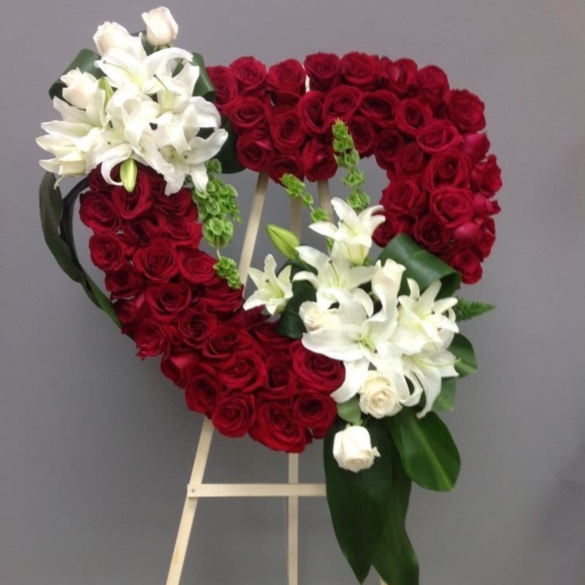 A large heart of tightly packed red roses framed with clusters of