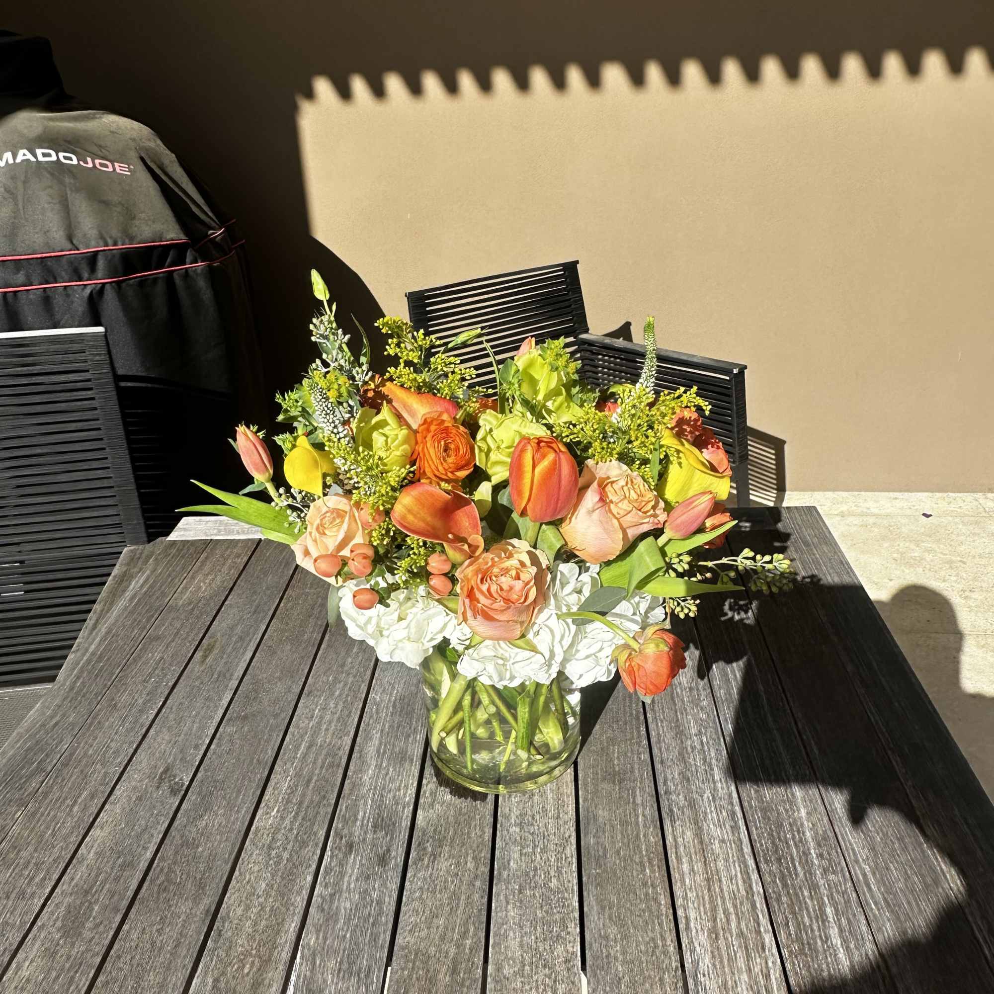 Mixed orange and peach bouquet in a clear glass vase