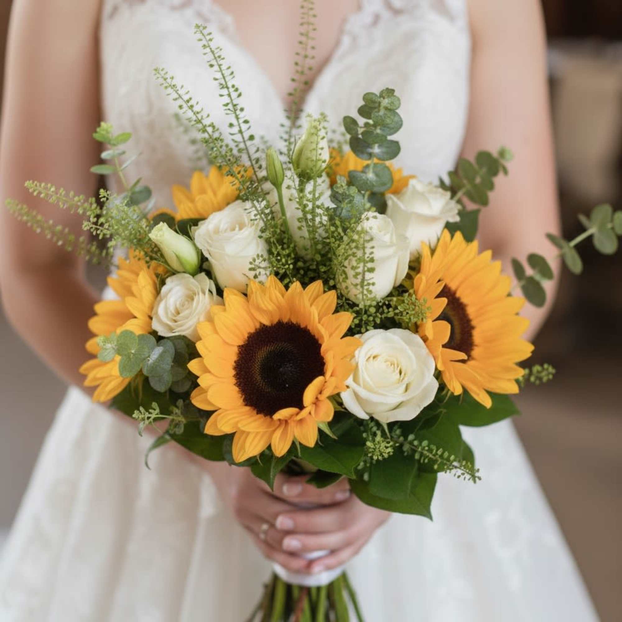 Bride holding a bouquet of sunflowers and white roses, photo 2 of 2