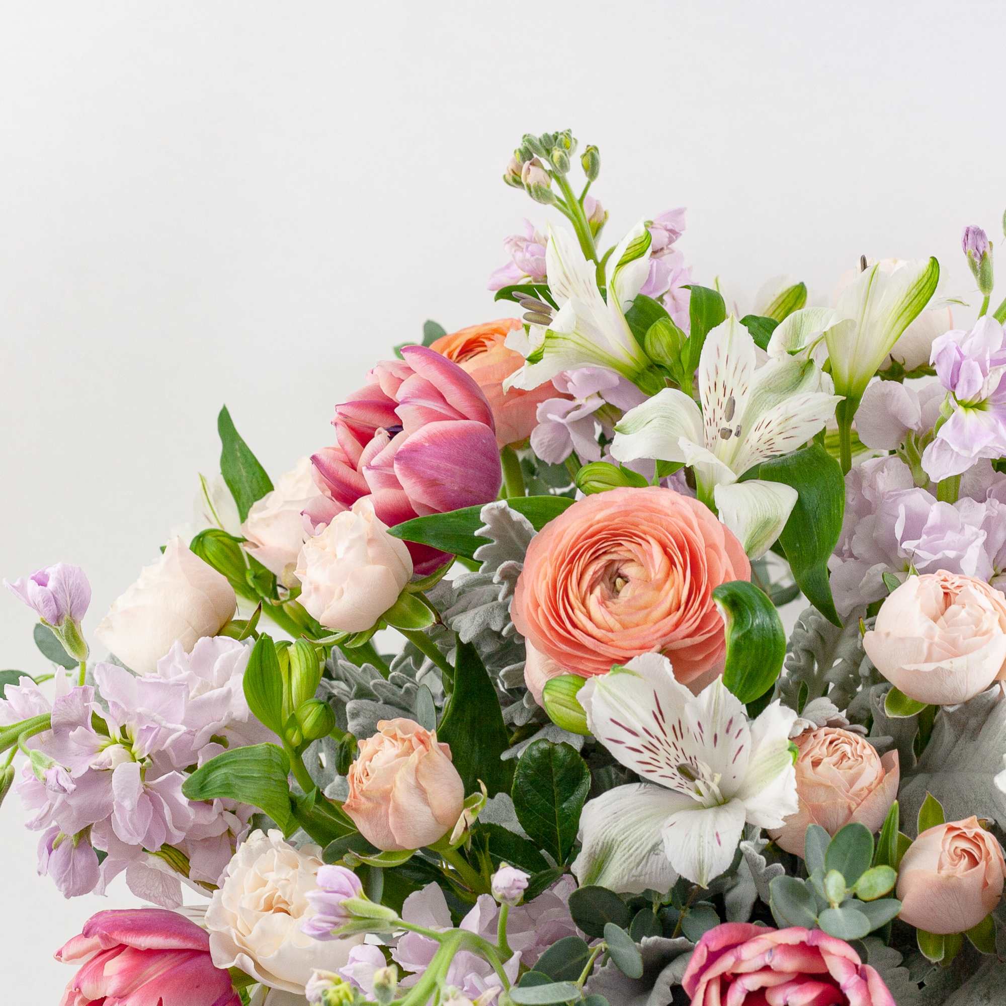 Pastel bouquet with roses, tulips, lilies, and ranunculus