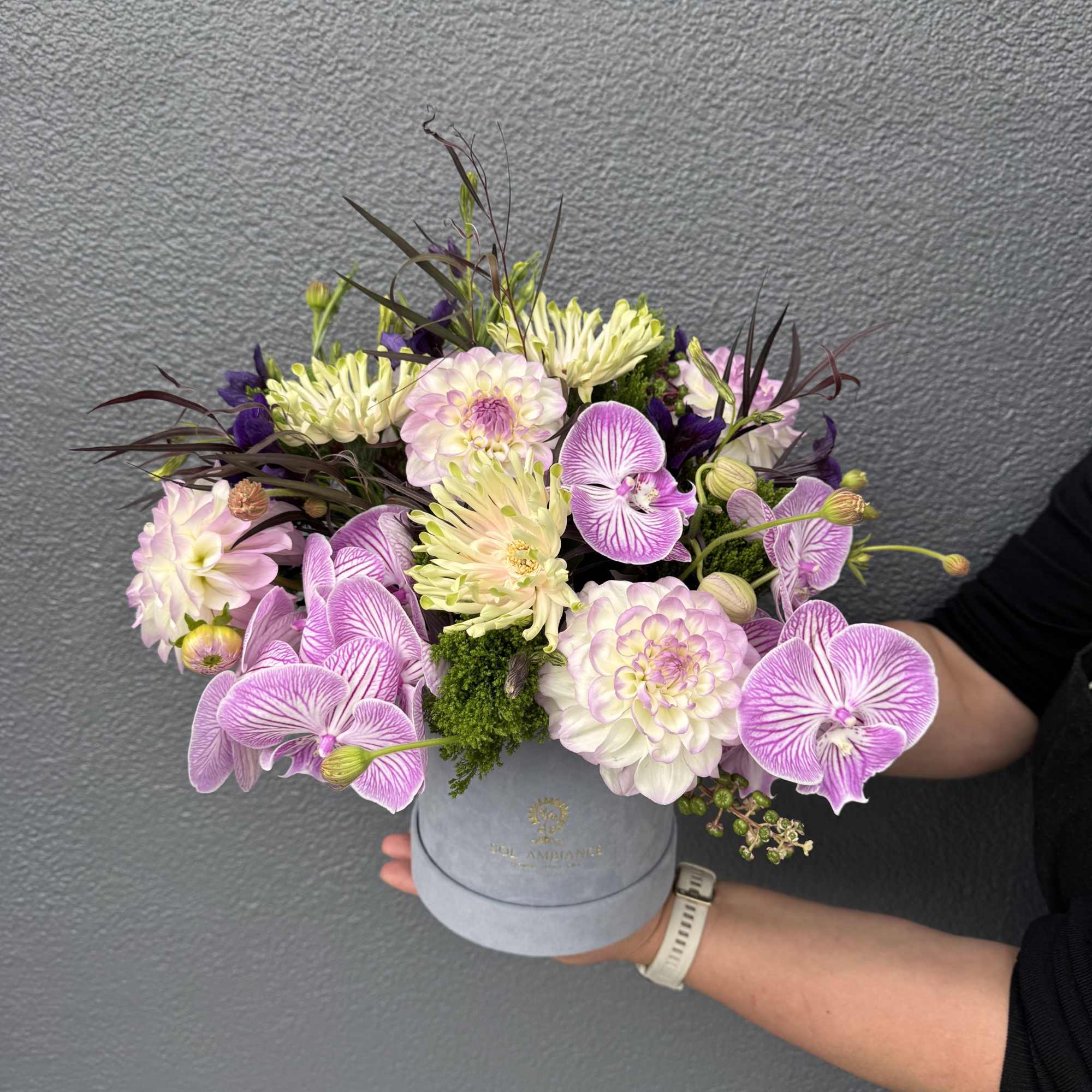 A mixed design of local lavender dahlias and lush orchids.

Our "What&rsquo;s in