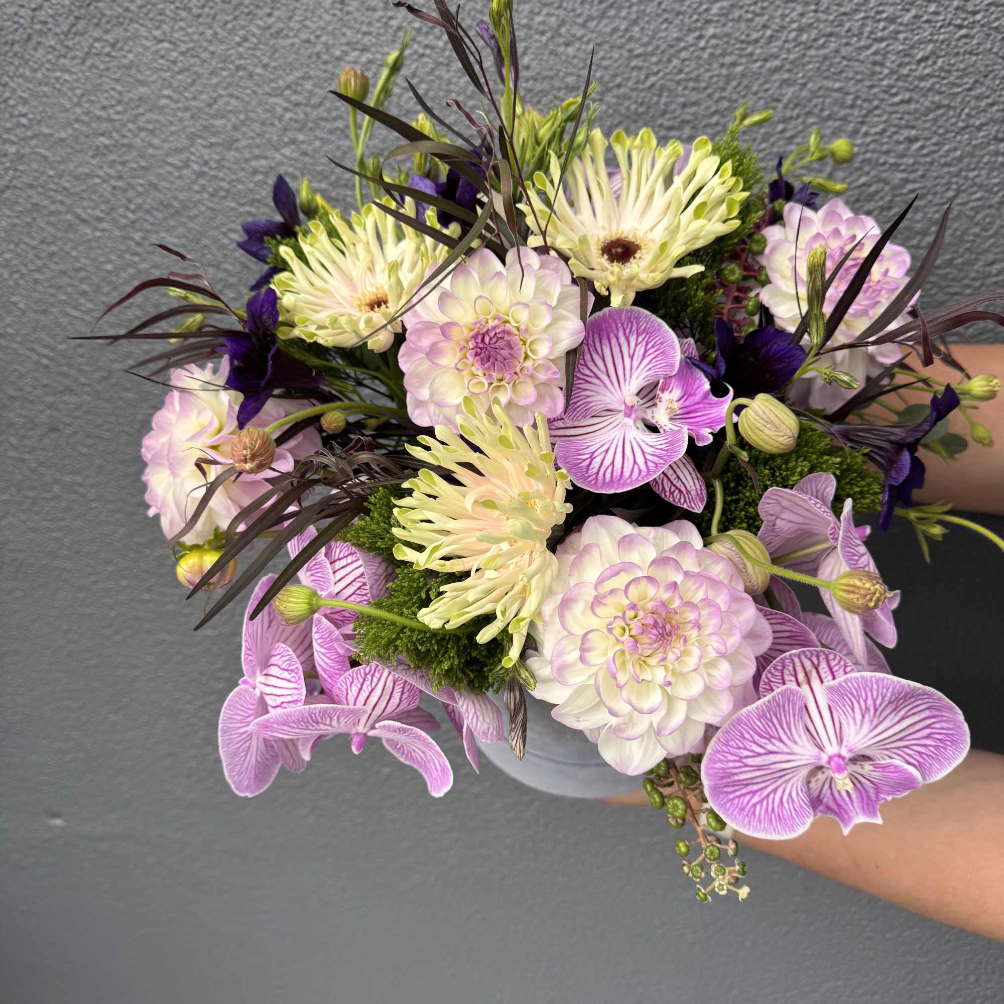 A mixed design of local lavender dahlias and lush orchids.

Our "What&rsquo;s in, photo 2 of 2