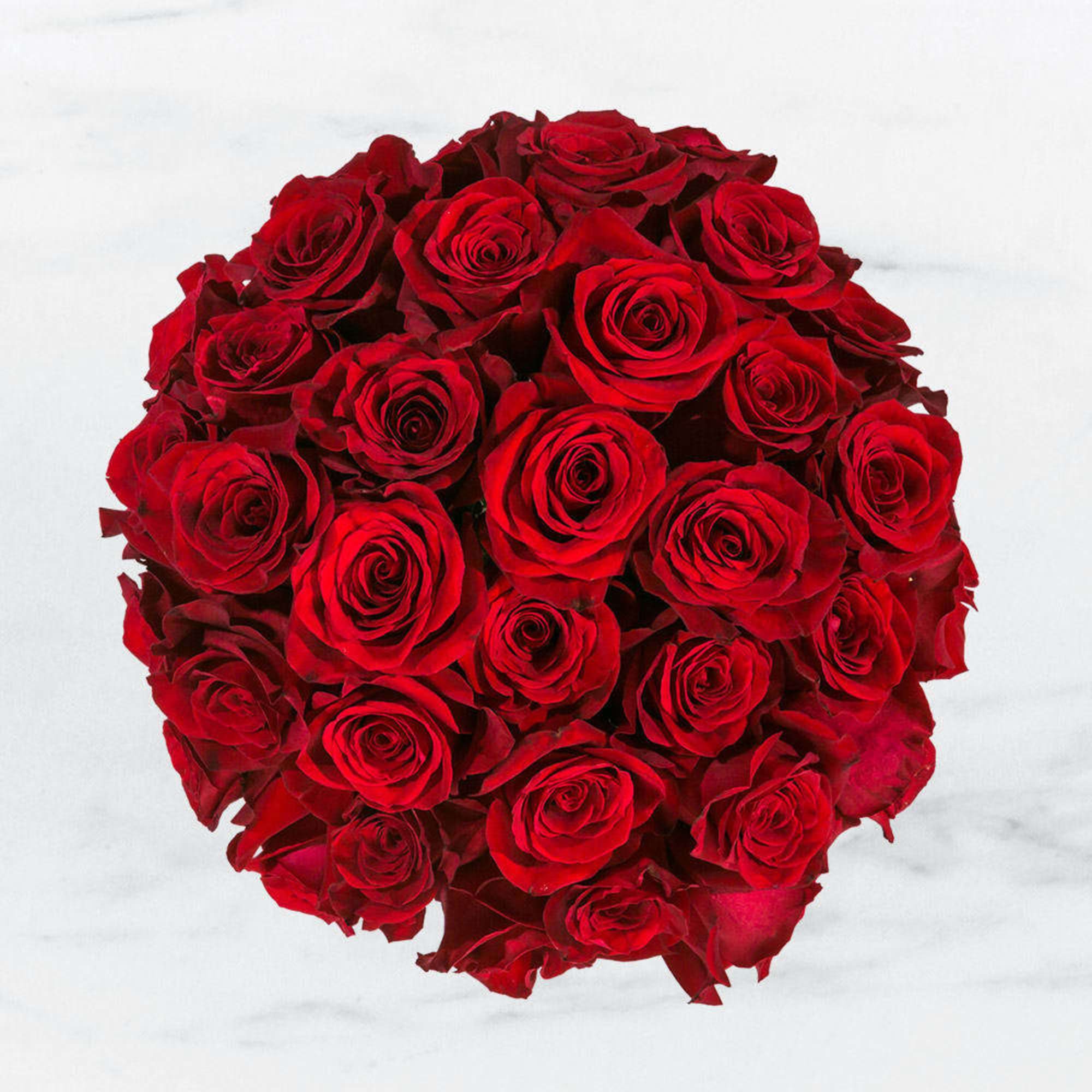 Tightly clustered round bouquet of red roses viewed from above.