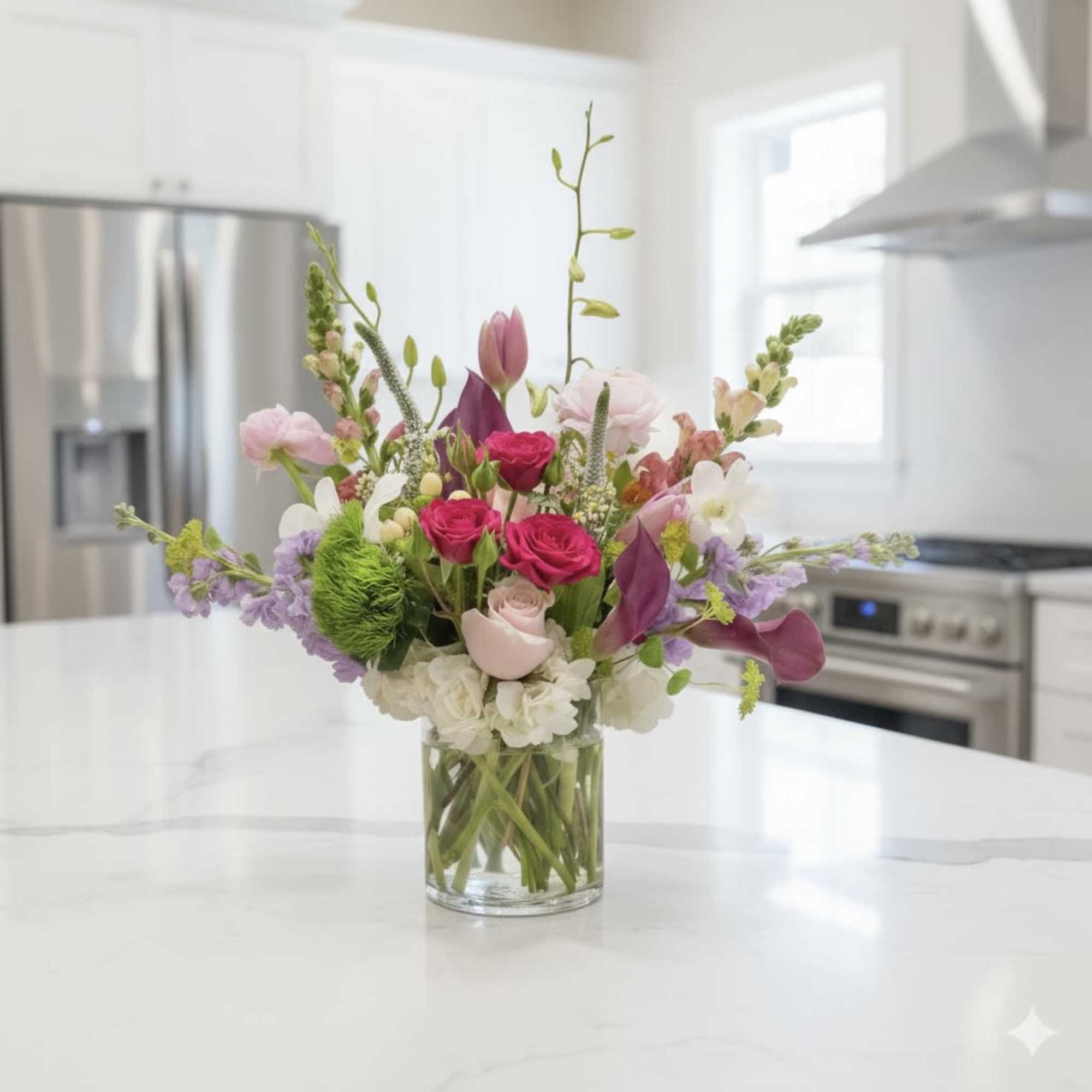 Mixed pink and white flower arrangement in a clear glass vase