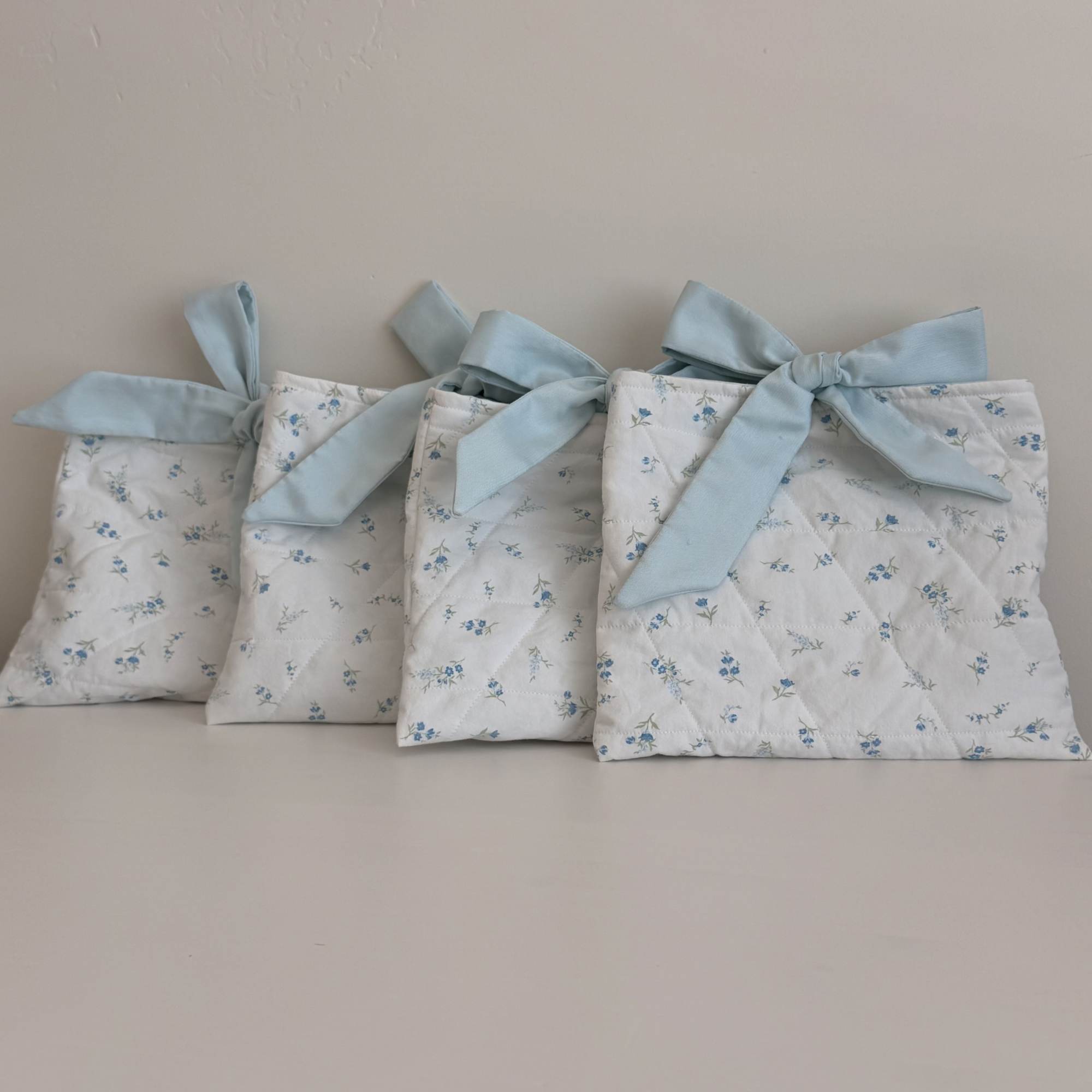 Delicate hand-quilted fabric pouche make a charming alternative gift presentation for a