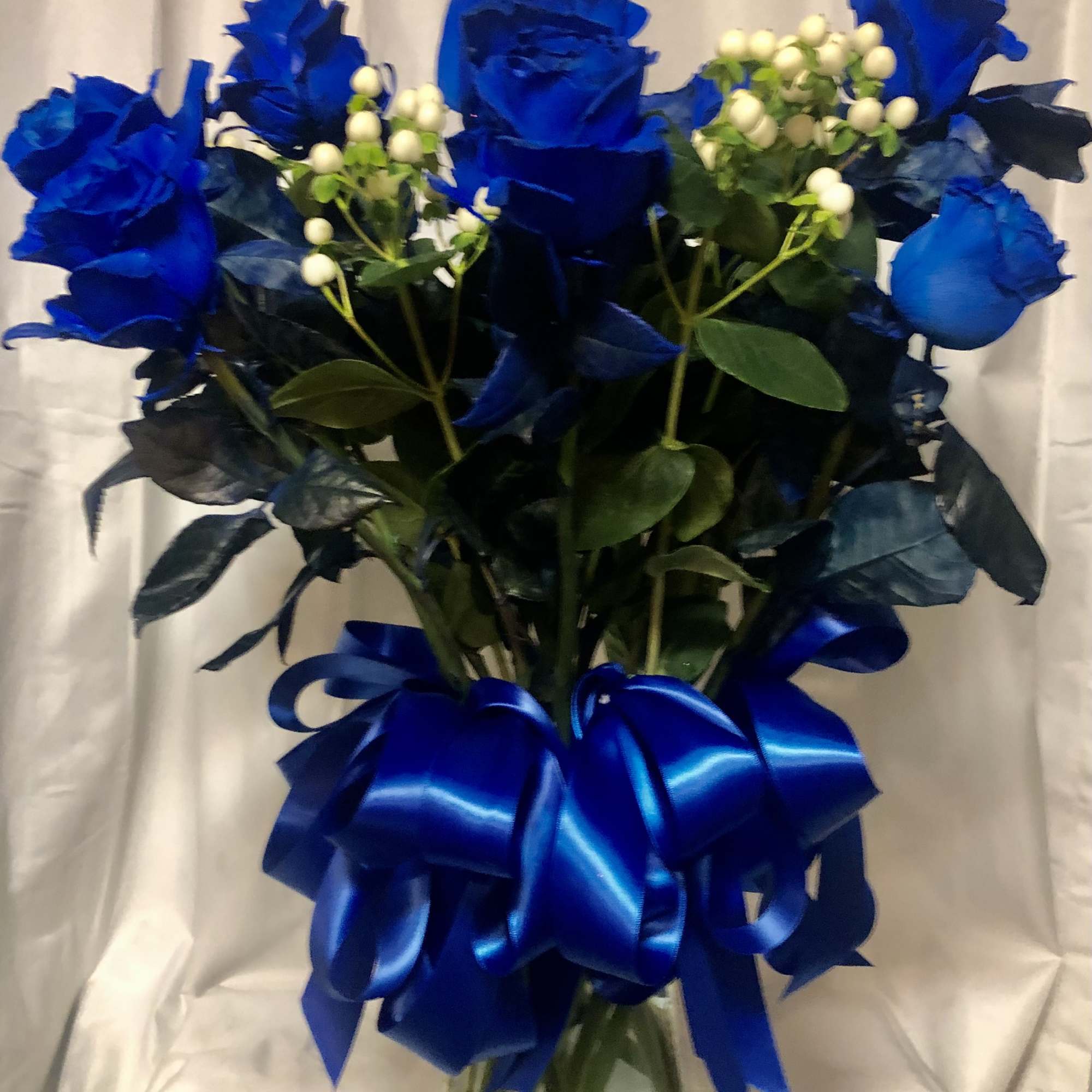 A dozen blue roses in a custom vase.