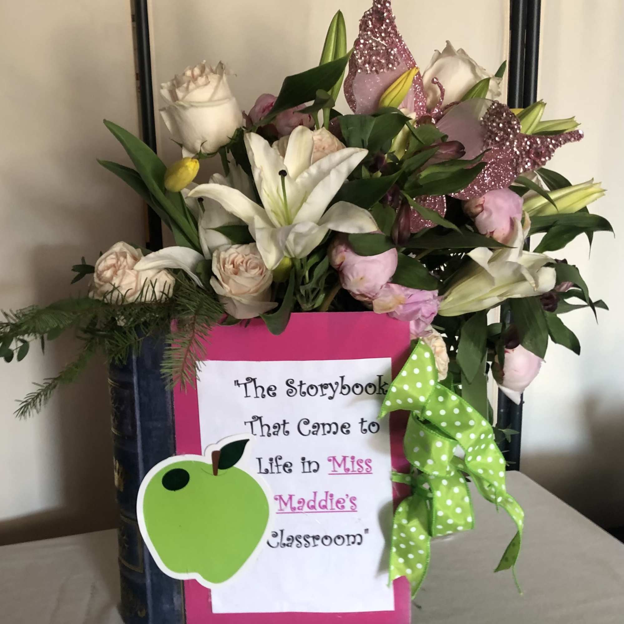 Bouquet of white lilies and pale roses in a decorated book-shaped container
