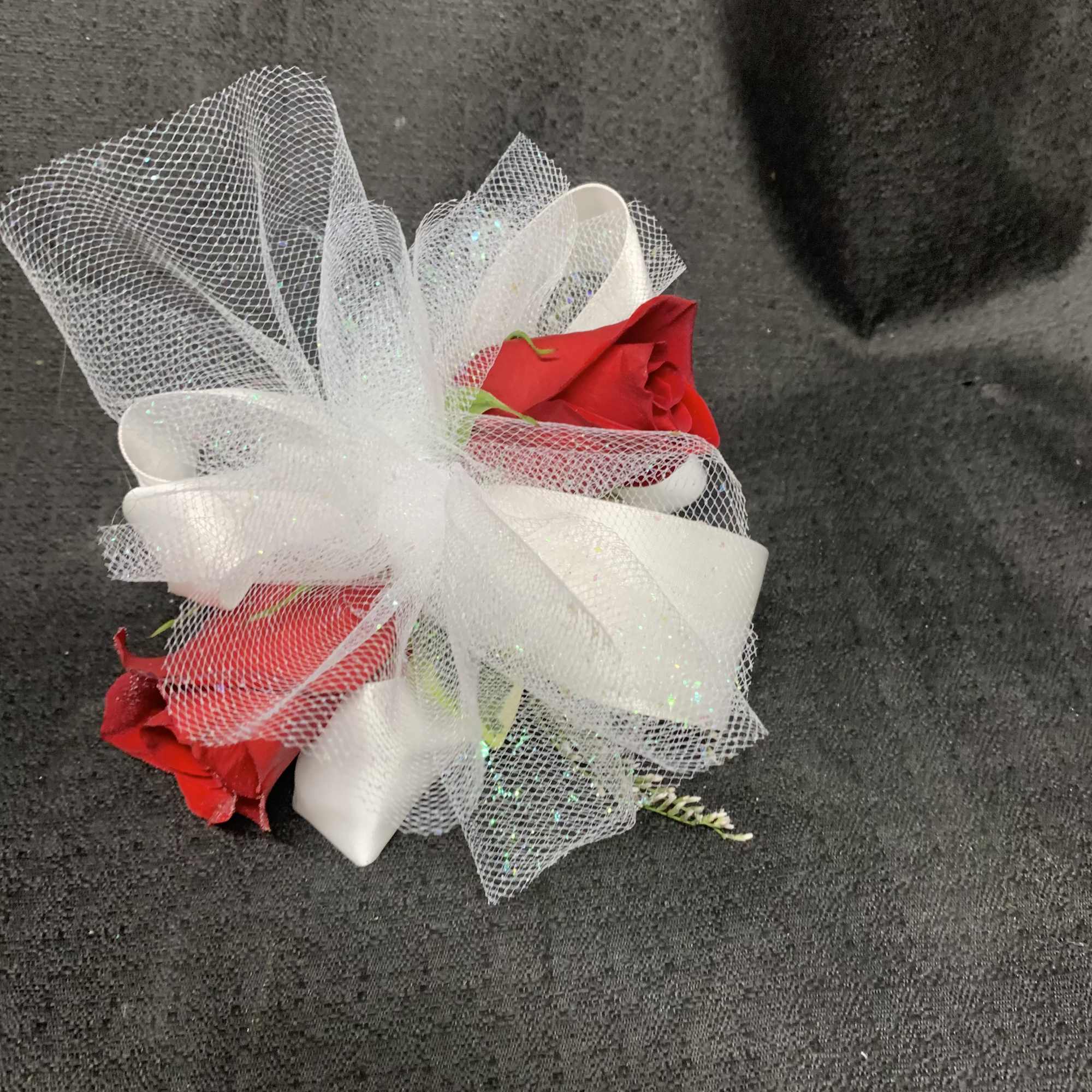 Two red roses wrapped in white mesh ribbon