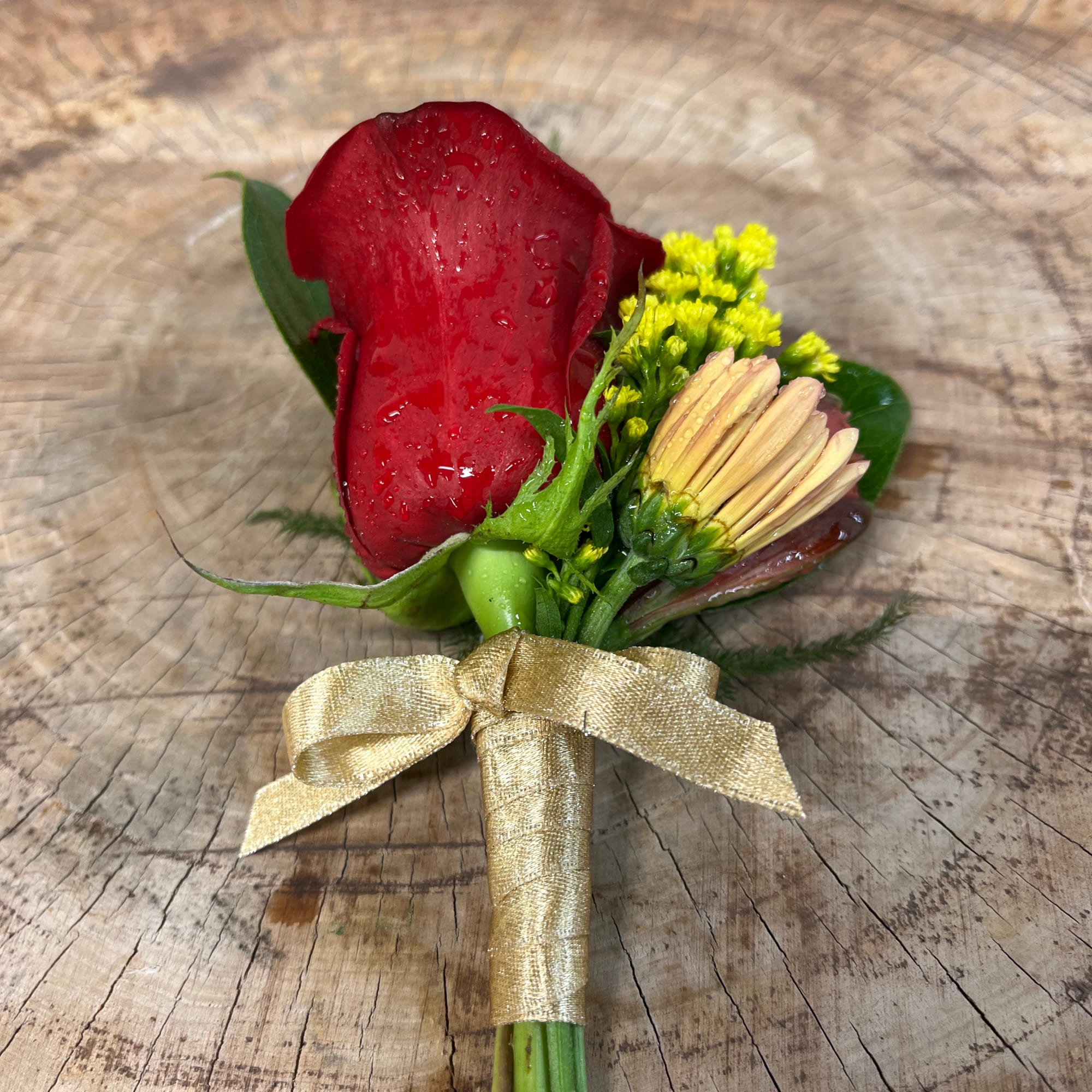 Red rose boutonniere with a yellow bloom and gold ribbon wrap