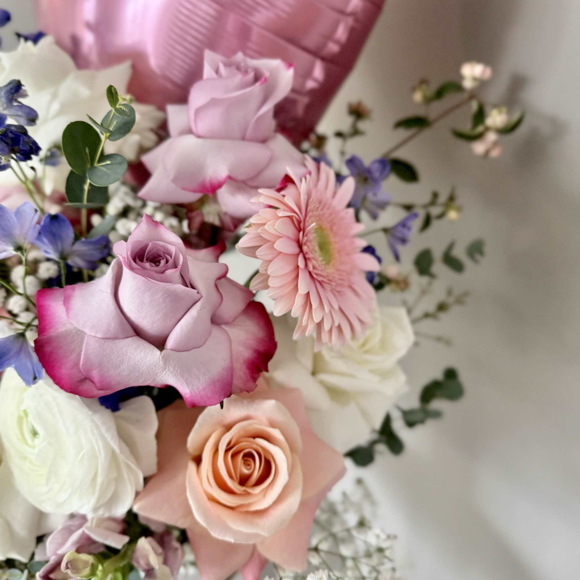 Bouquet of pink and white roses with a pink balloon