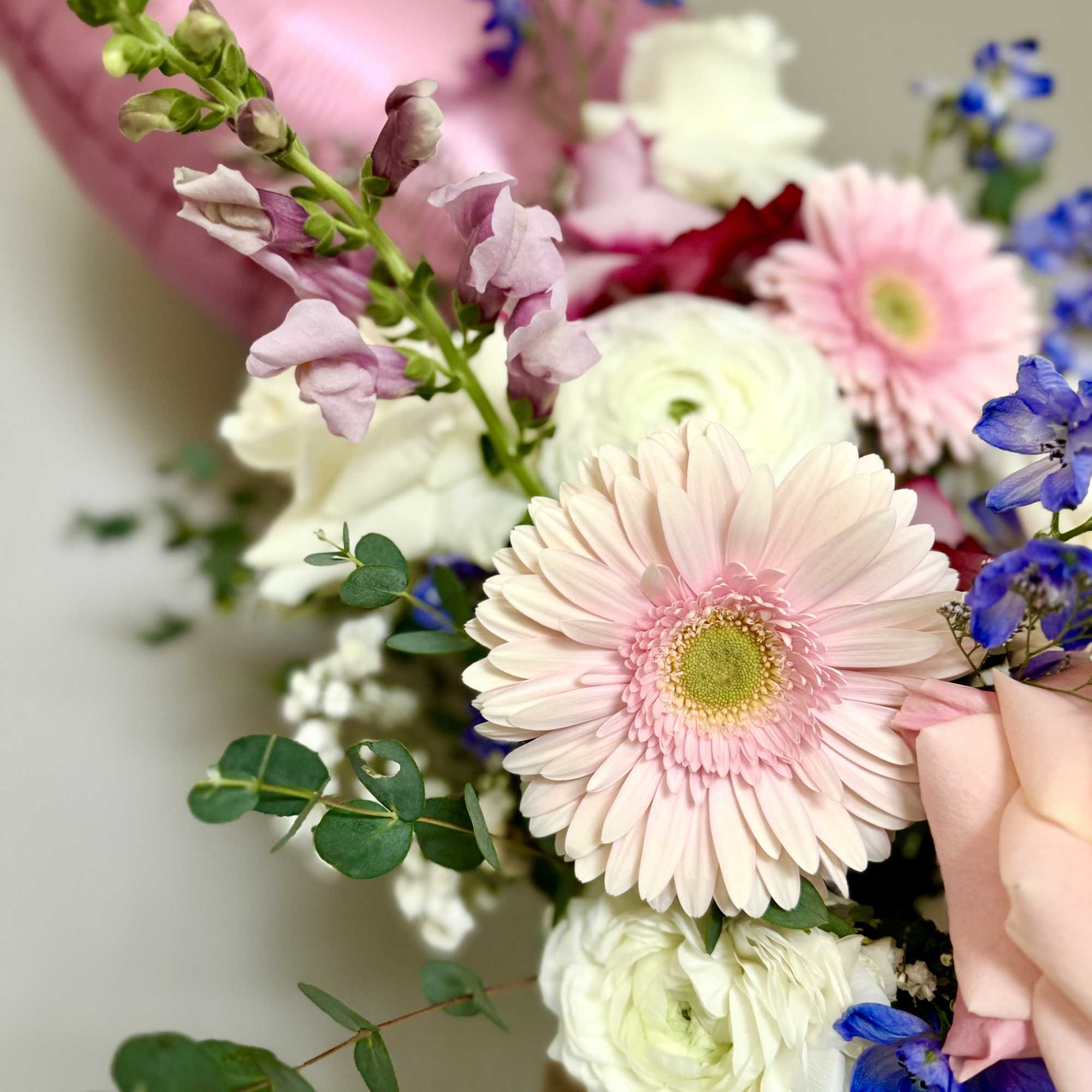 Pastel bouquet with pink gerbera daisies and blue flowers