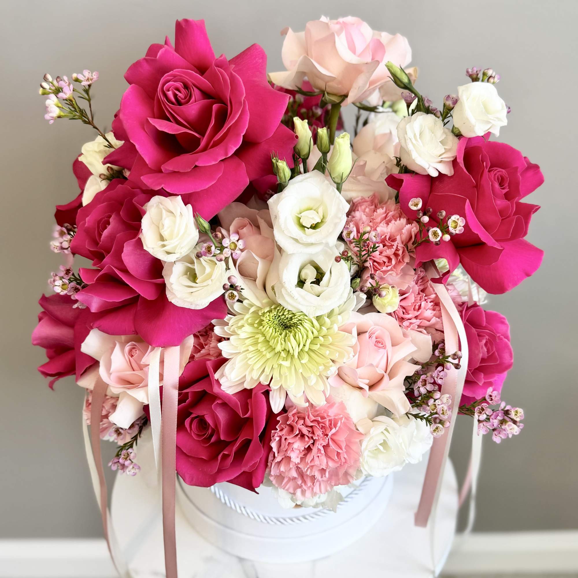 Pink and white rose bouquet in a white hat box