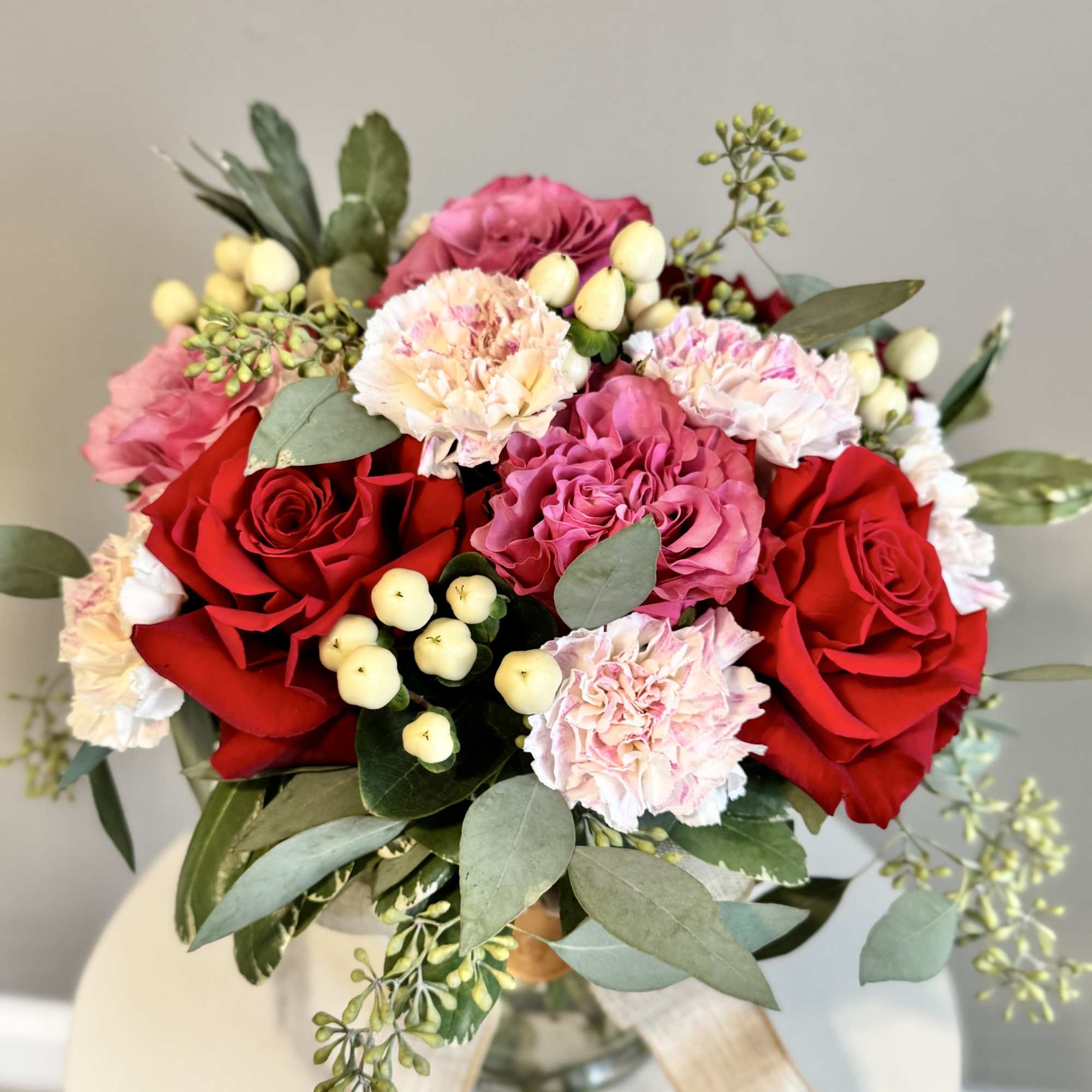 Bouquet of red roses and pink carnations in a glass vase