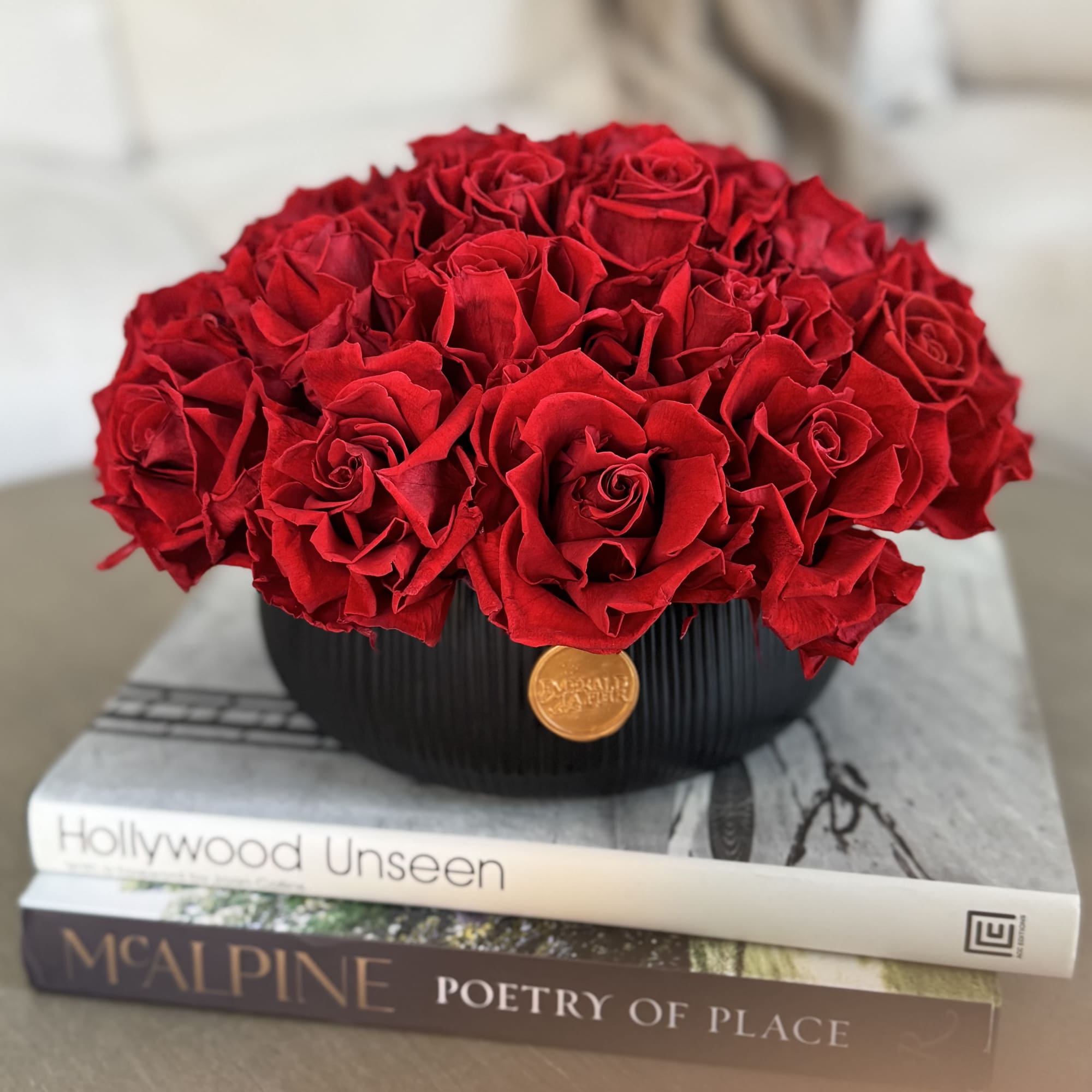 Round bouquet of red roses in a black vase