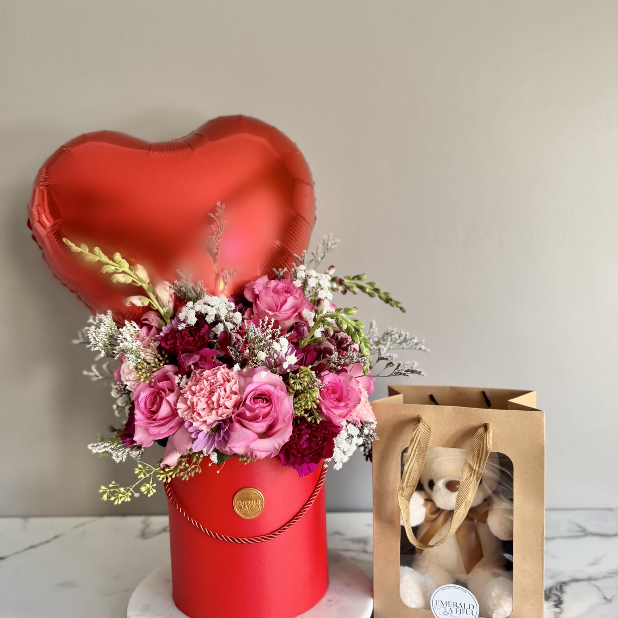 Pink rose bouquet in a red heart box with a teddy bear gift bag