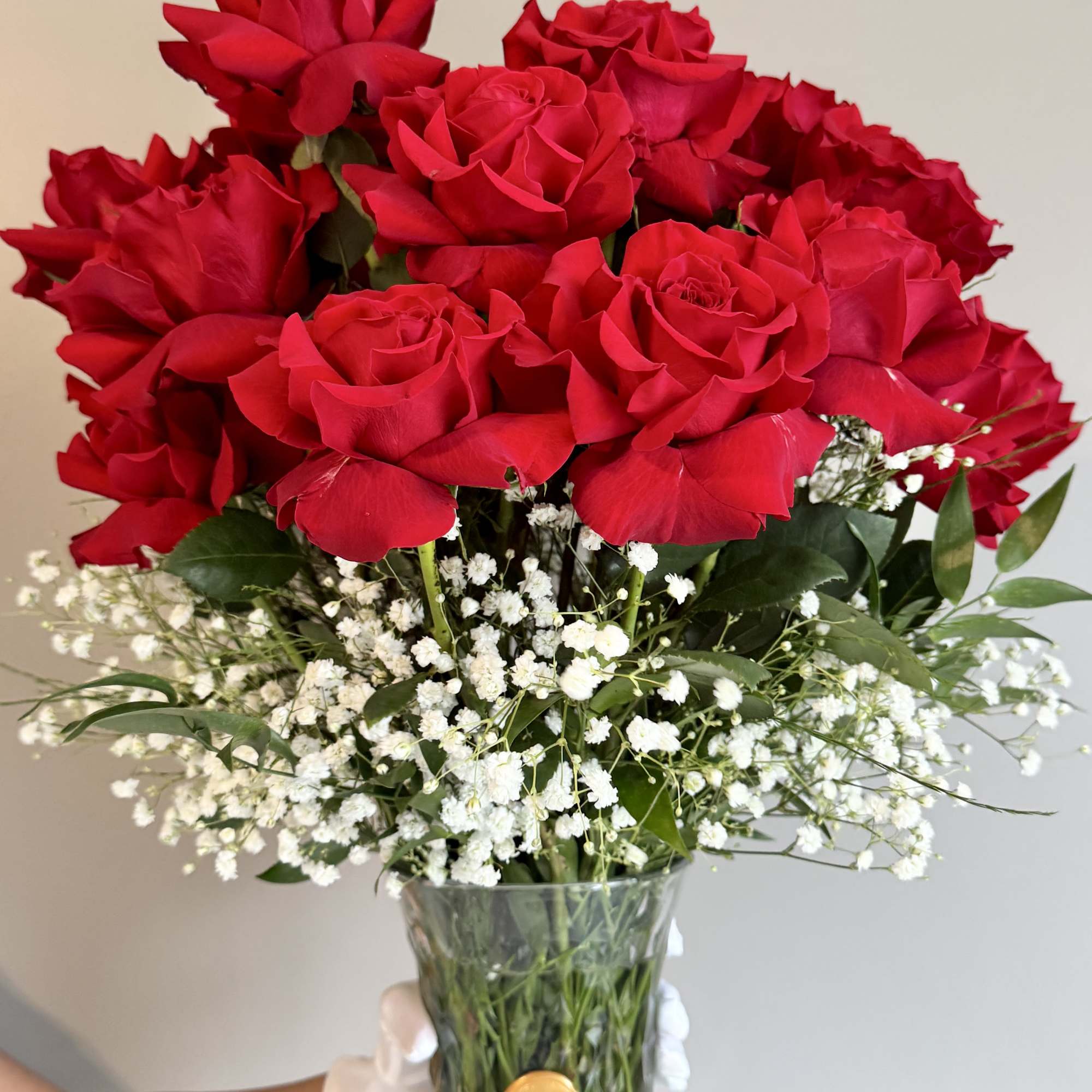 Bouquet of red roses with white baby's breath in a glass vase