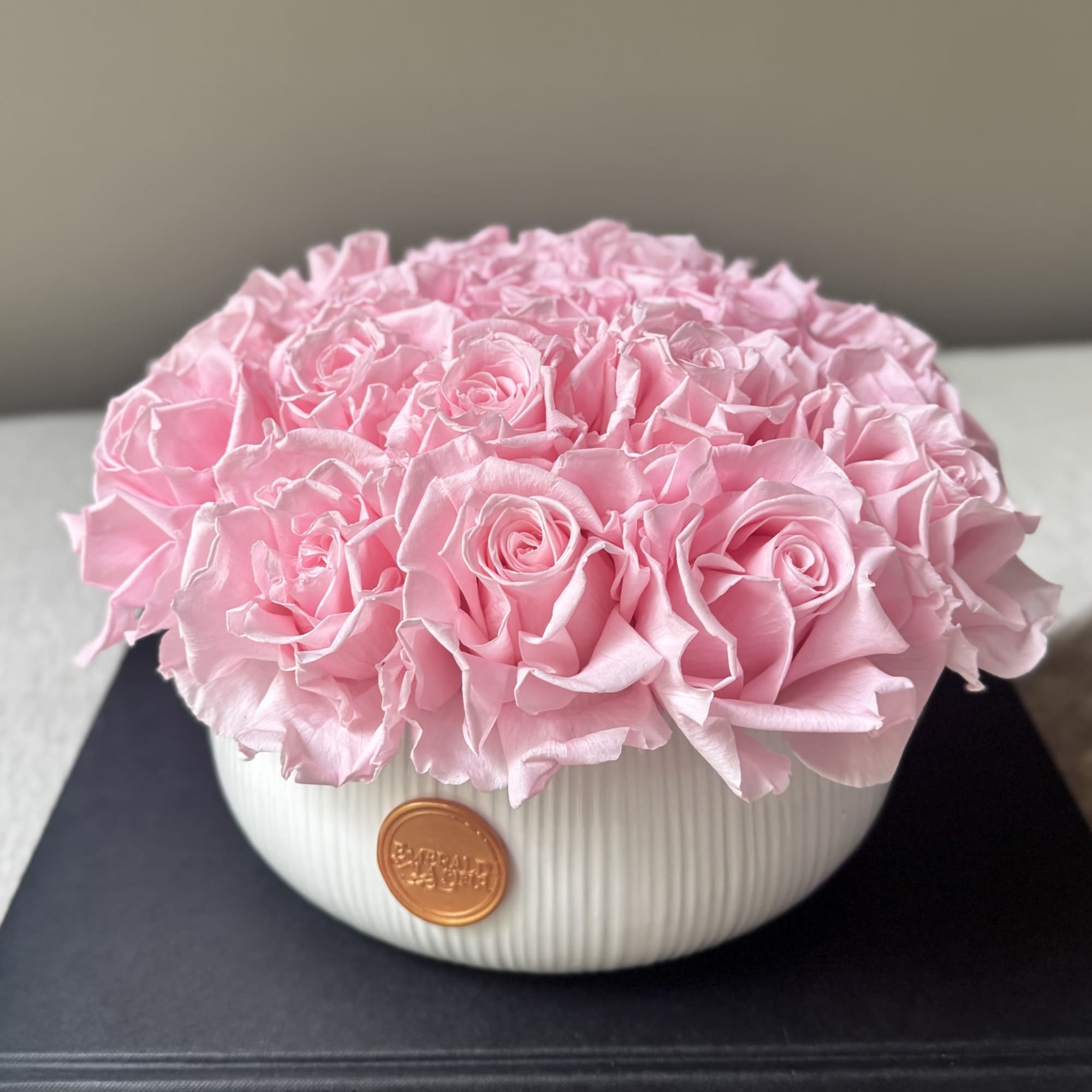 Pink rose arrangement in a white ribbed bowl