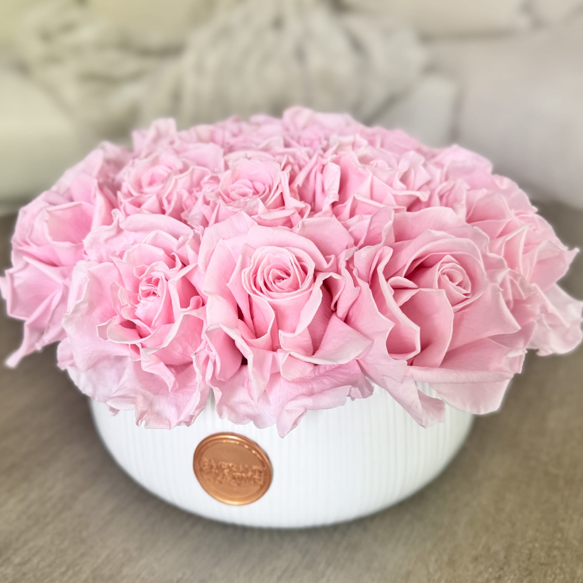 Pink roses arranged in a white round box