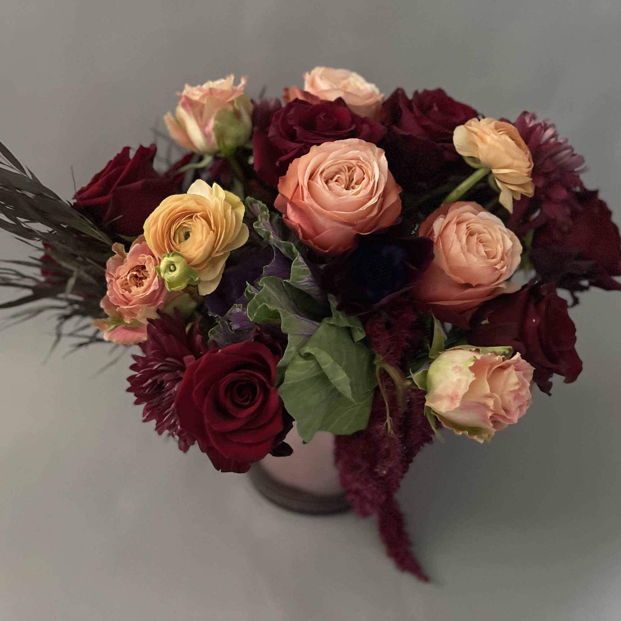 Bouquet of burgundy and peach roses in a vase