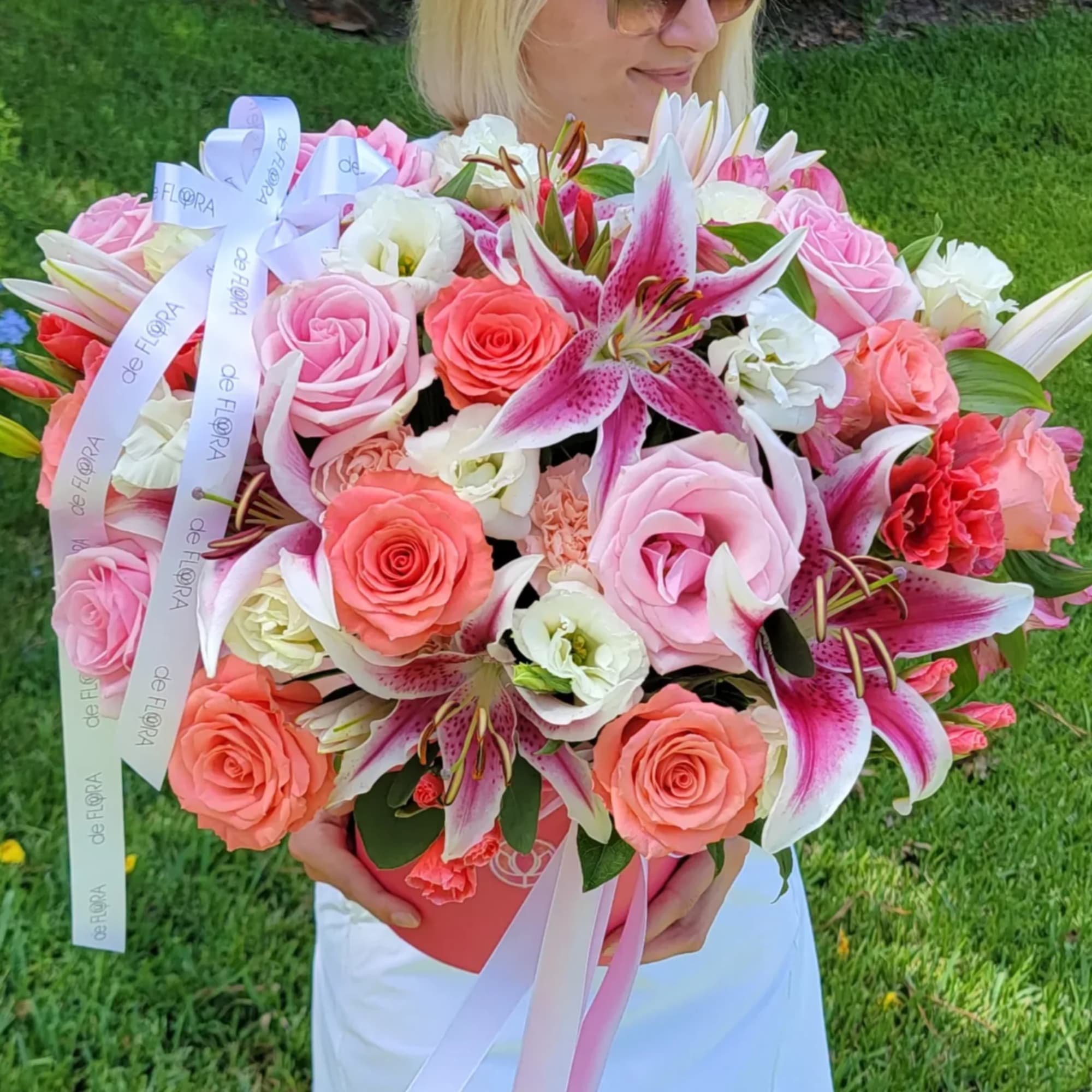 Large bouquet of pink roses and lilies with ribbon in a box