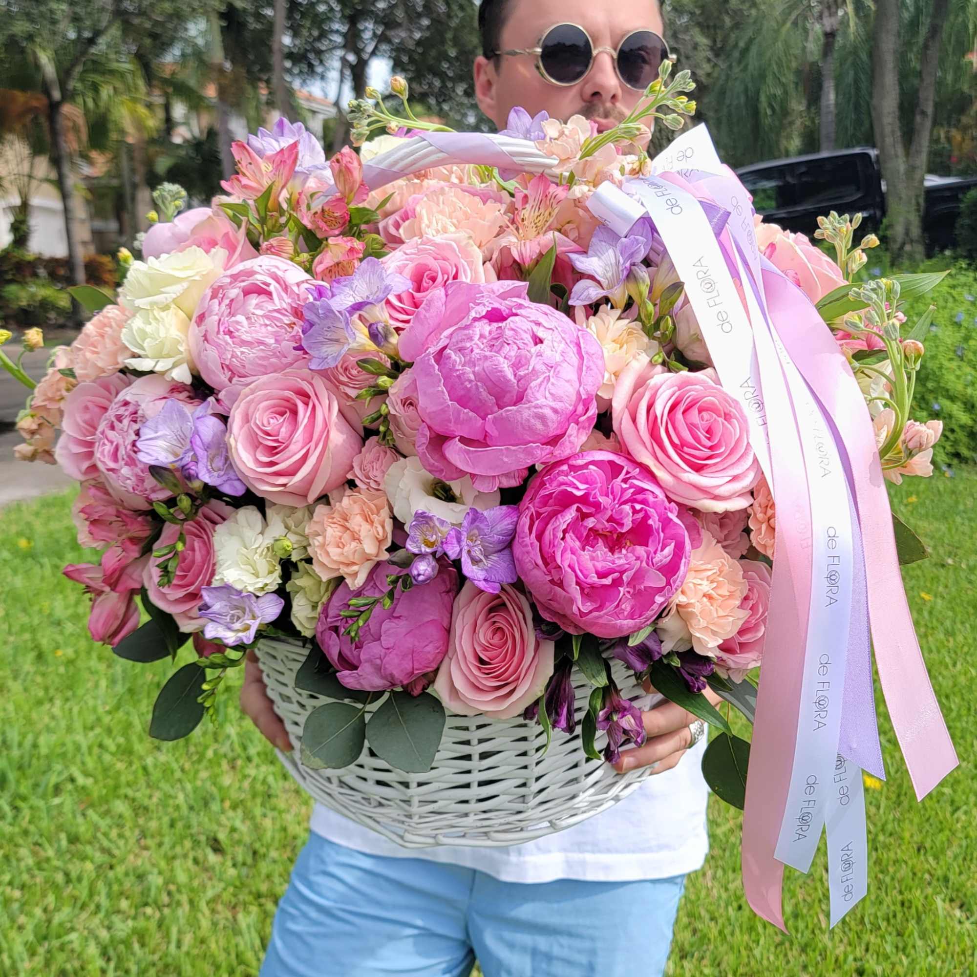 Large basket of pink and lavender flowers with ribbon